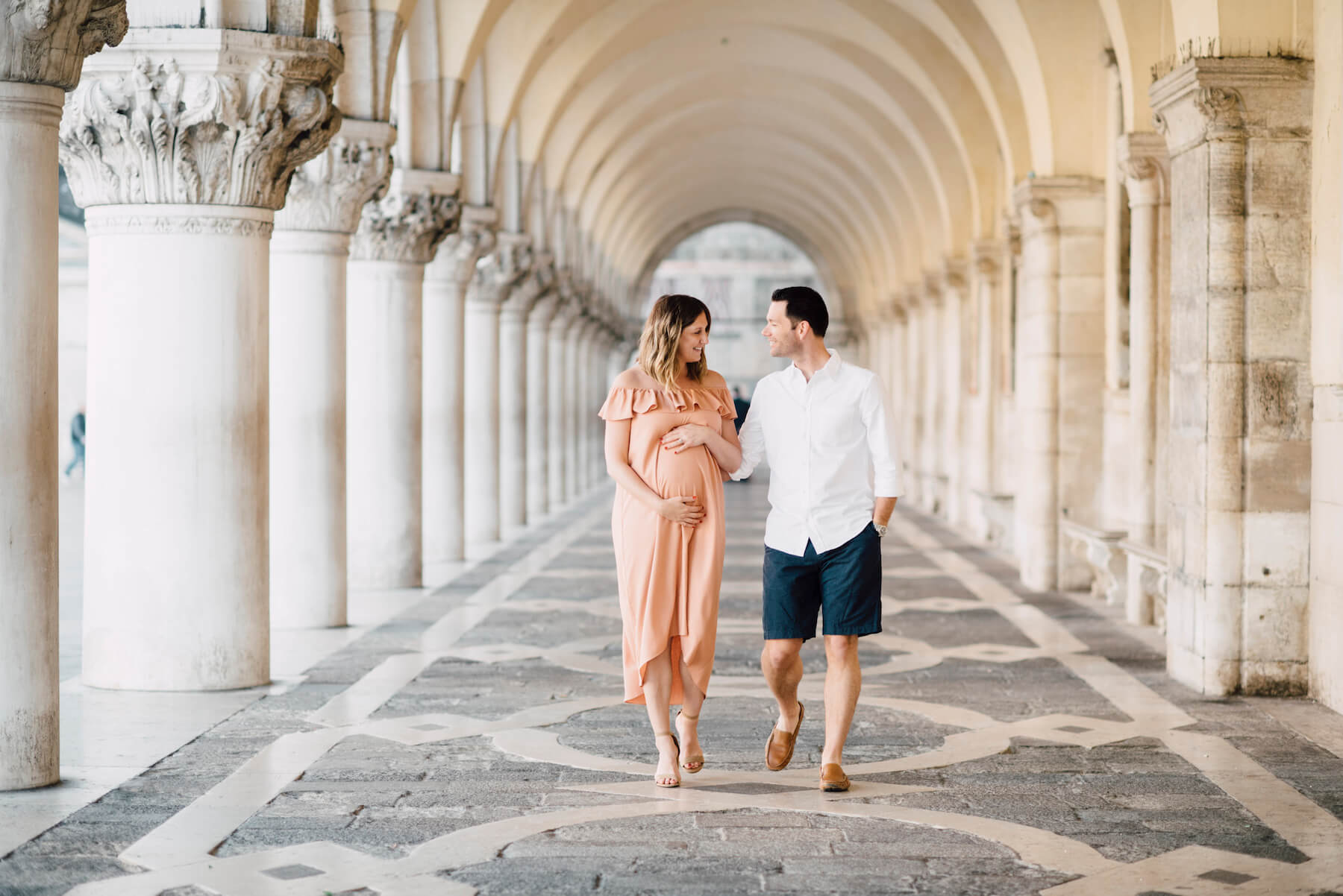 pregnant couple walking along San Marco square in Venice, Italy