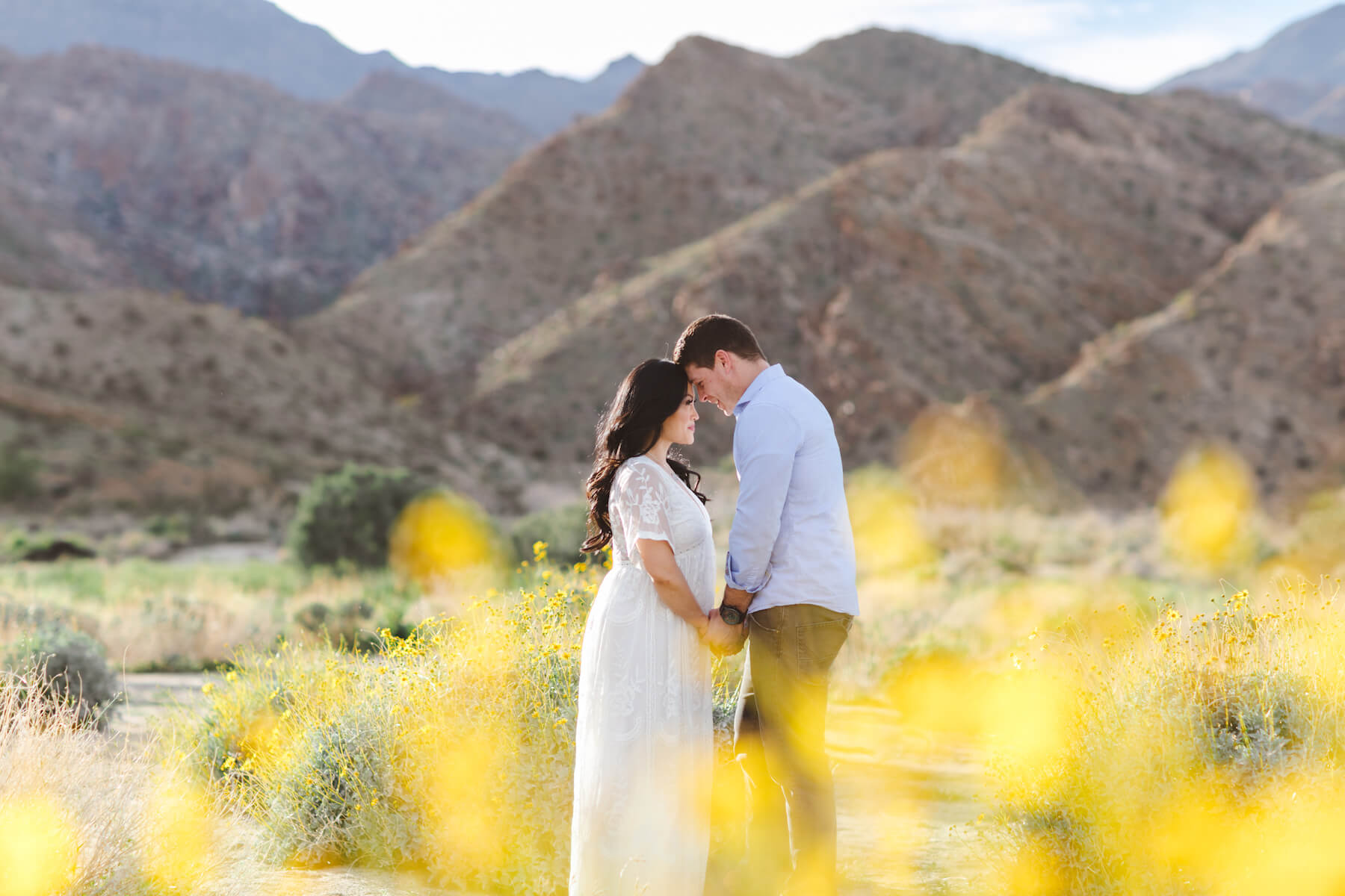 pregnant couple looking at each other in the desert in Palm Spring, California 