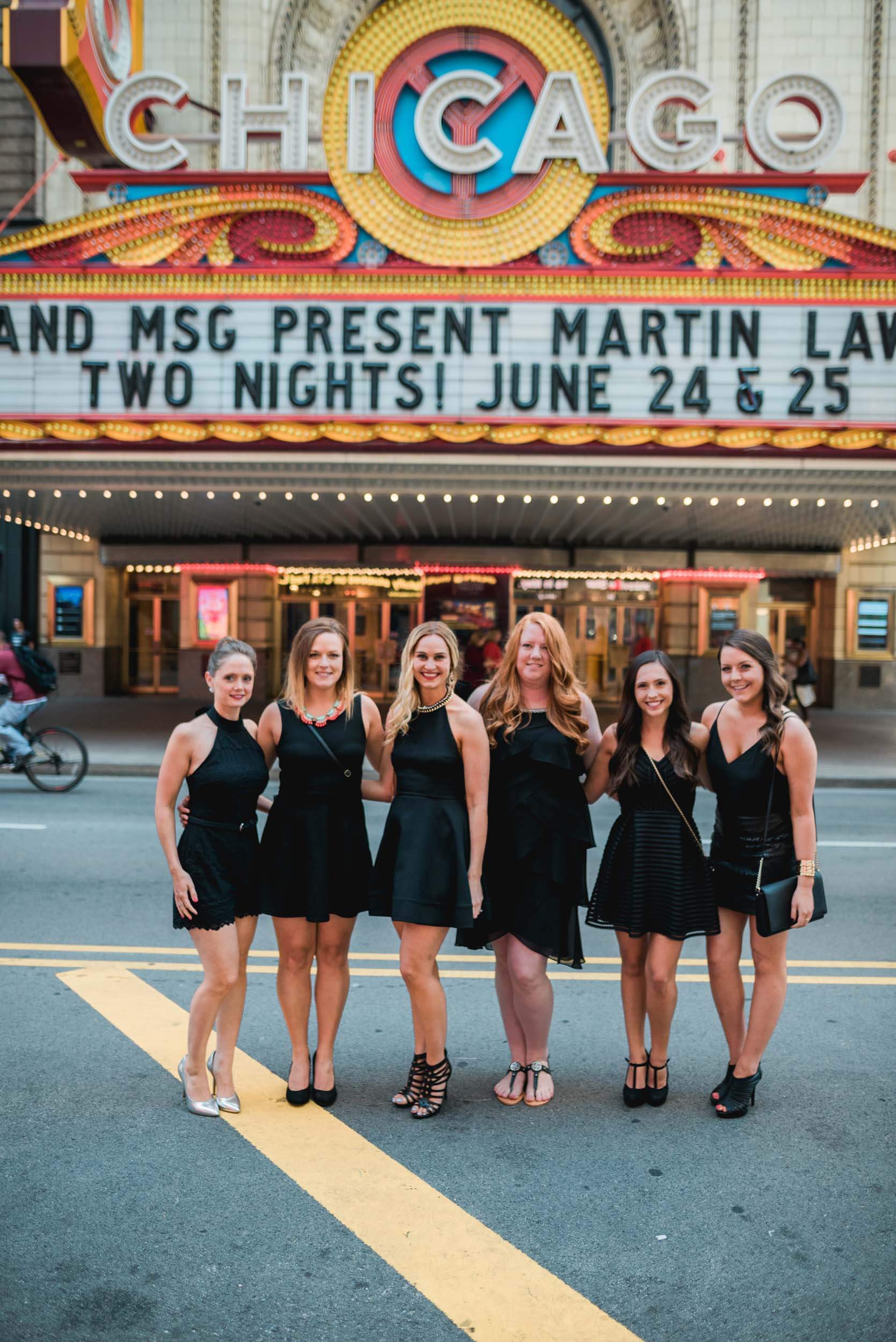 Six female friends on a bachelorette trip together in front of the Chicago theatre in Chicago, USA