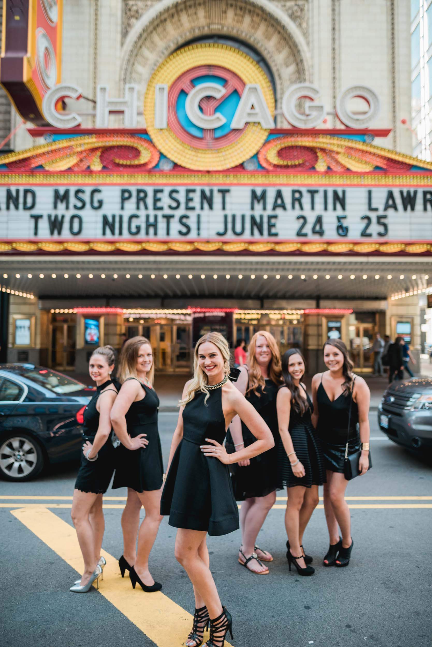 Six female friends on a bachelorette trip together in front of the Chicago theatre in Chicago, USA