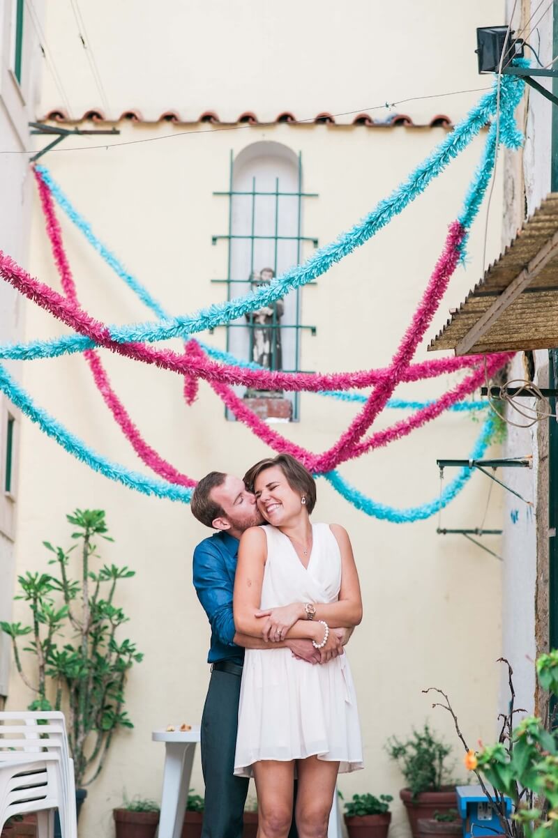 Man holding his partner and kissing her on the cheek on a couples trip in Lisbon, Portugal