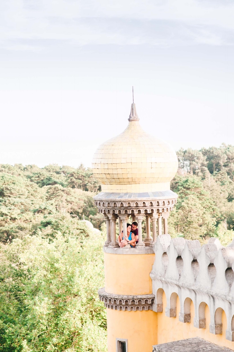 Couple standing in yellow pastel tower in the National Palace of Pena in Sintra, Portugal