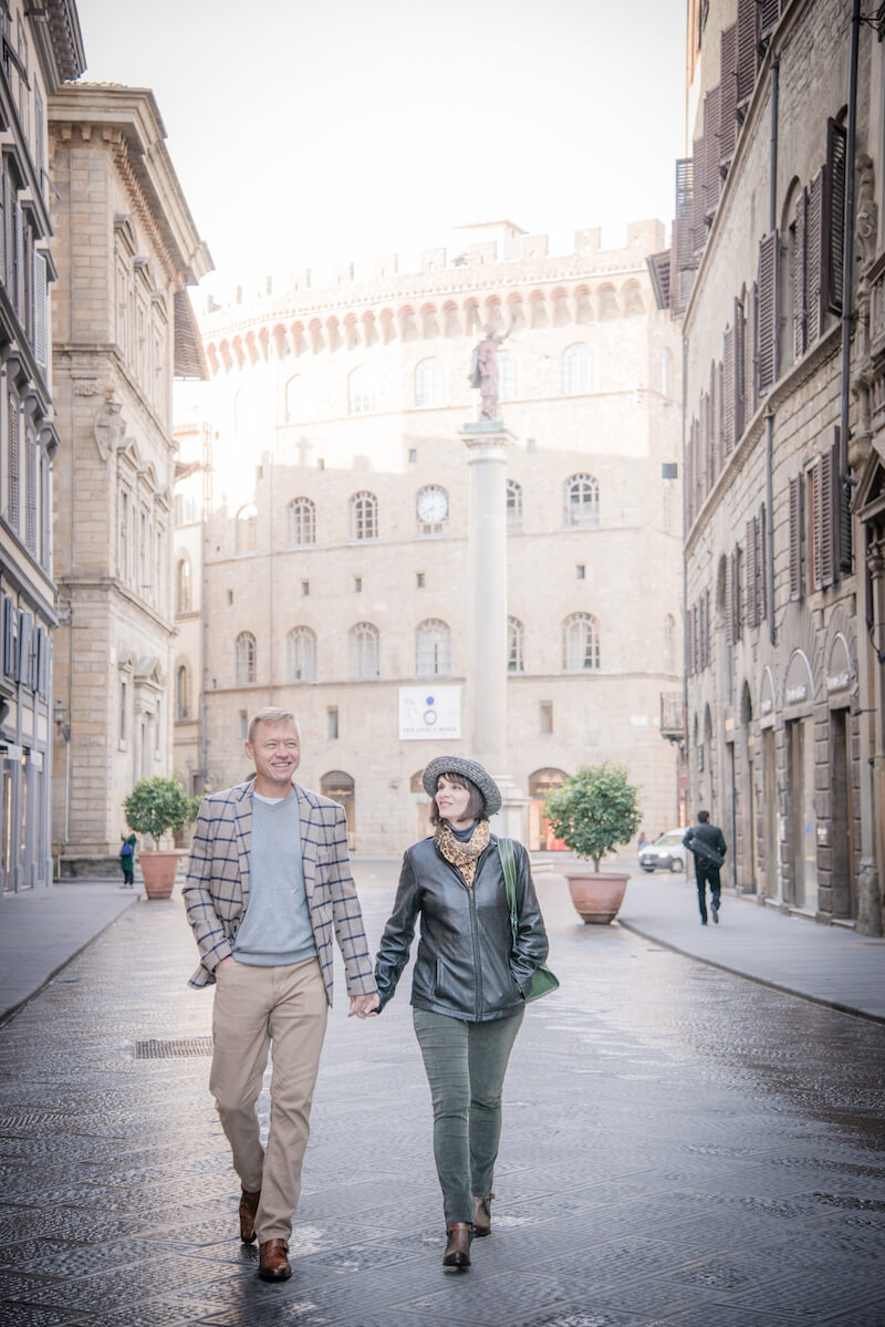 Couple holding hands and walking down a street in Florence, Italy