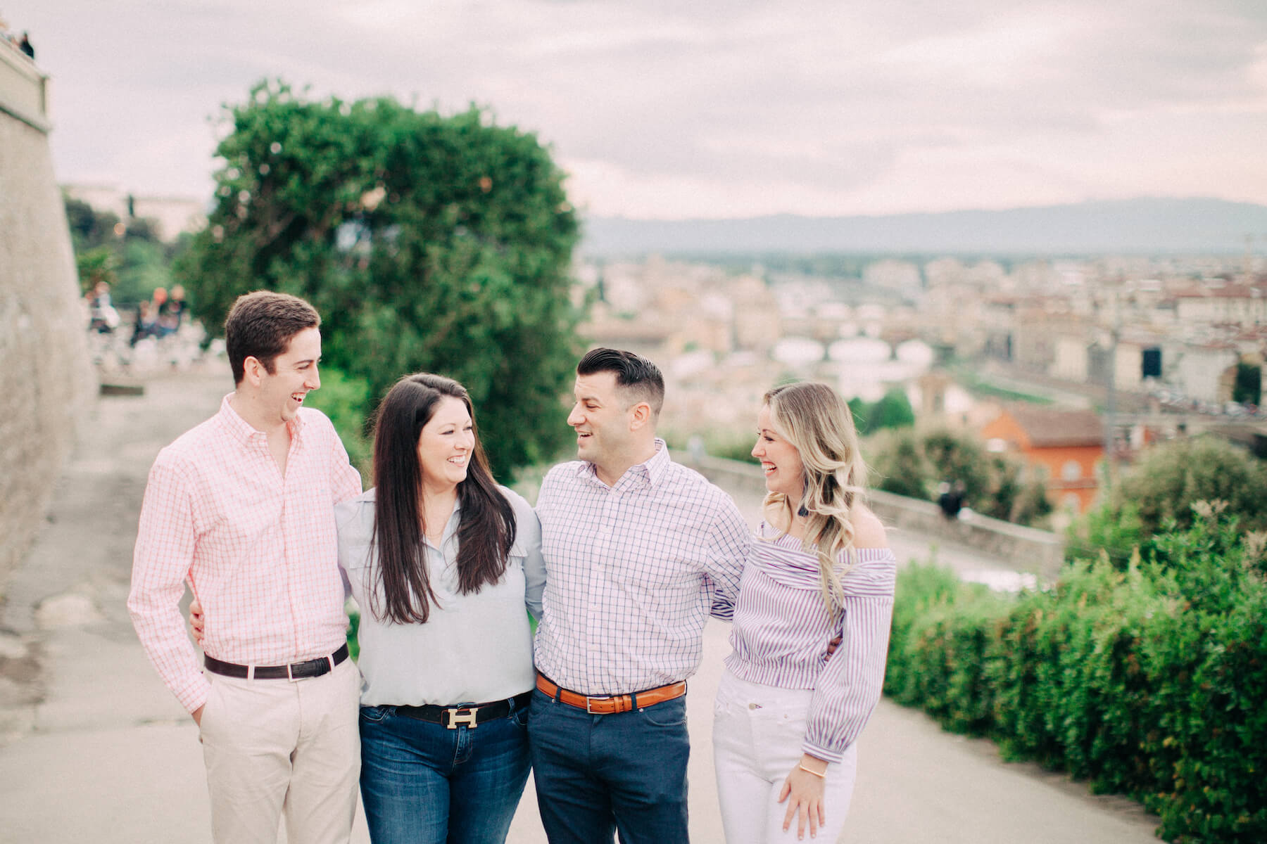 Family standing together and looking at each other smiling on family trip in Florence, Italy