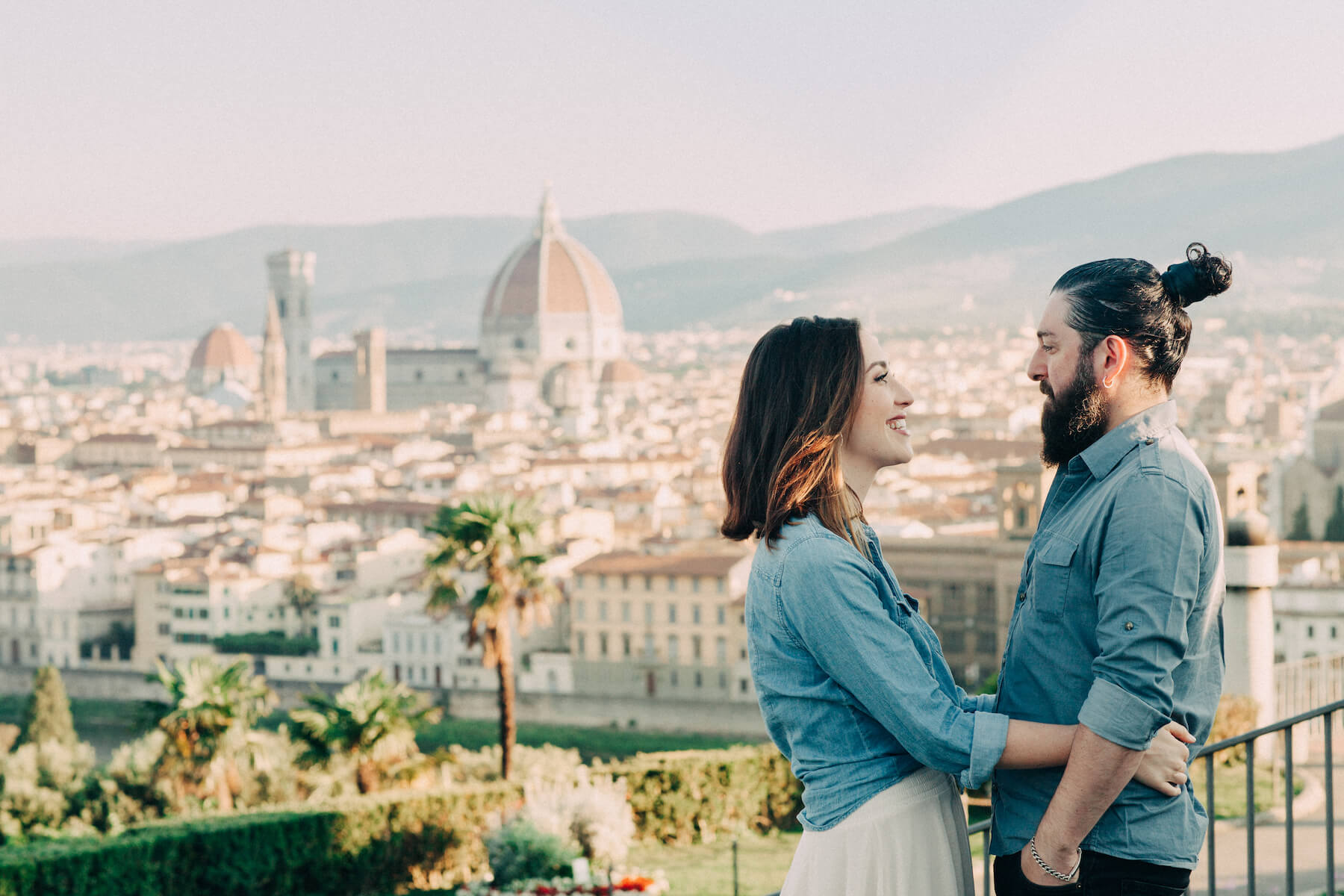 Couple hugging and overlooking the city at Piazzale Michelangelo in Florence, Italy