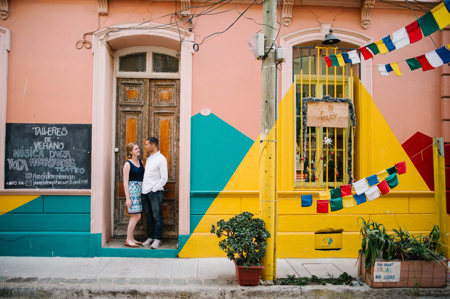 Couple standing in colourful restaurant doorway together in Valparaíso, Chile