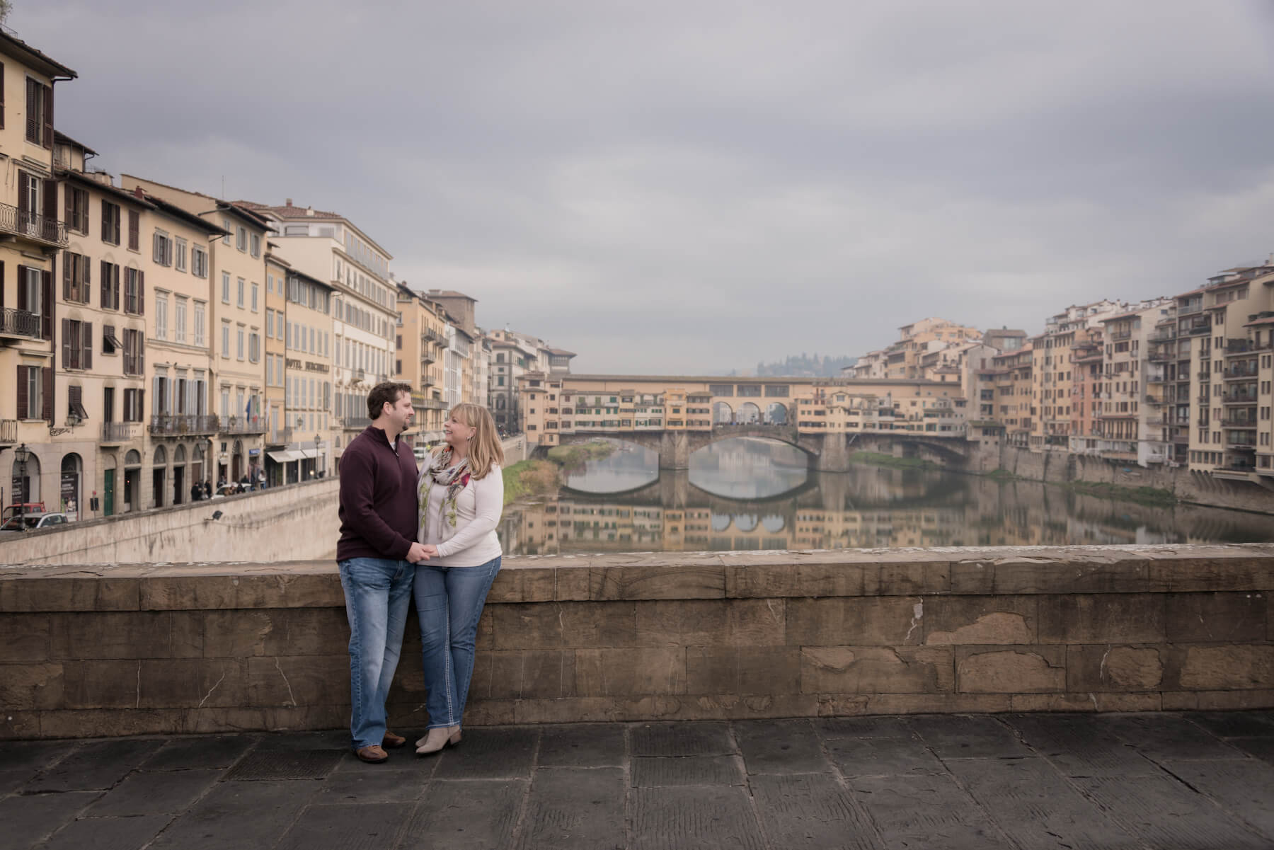 Couple looking lovingly at each other on a trip together at Ponte Vecchio in Florence, Italy