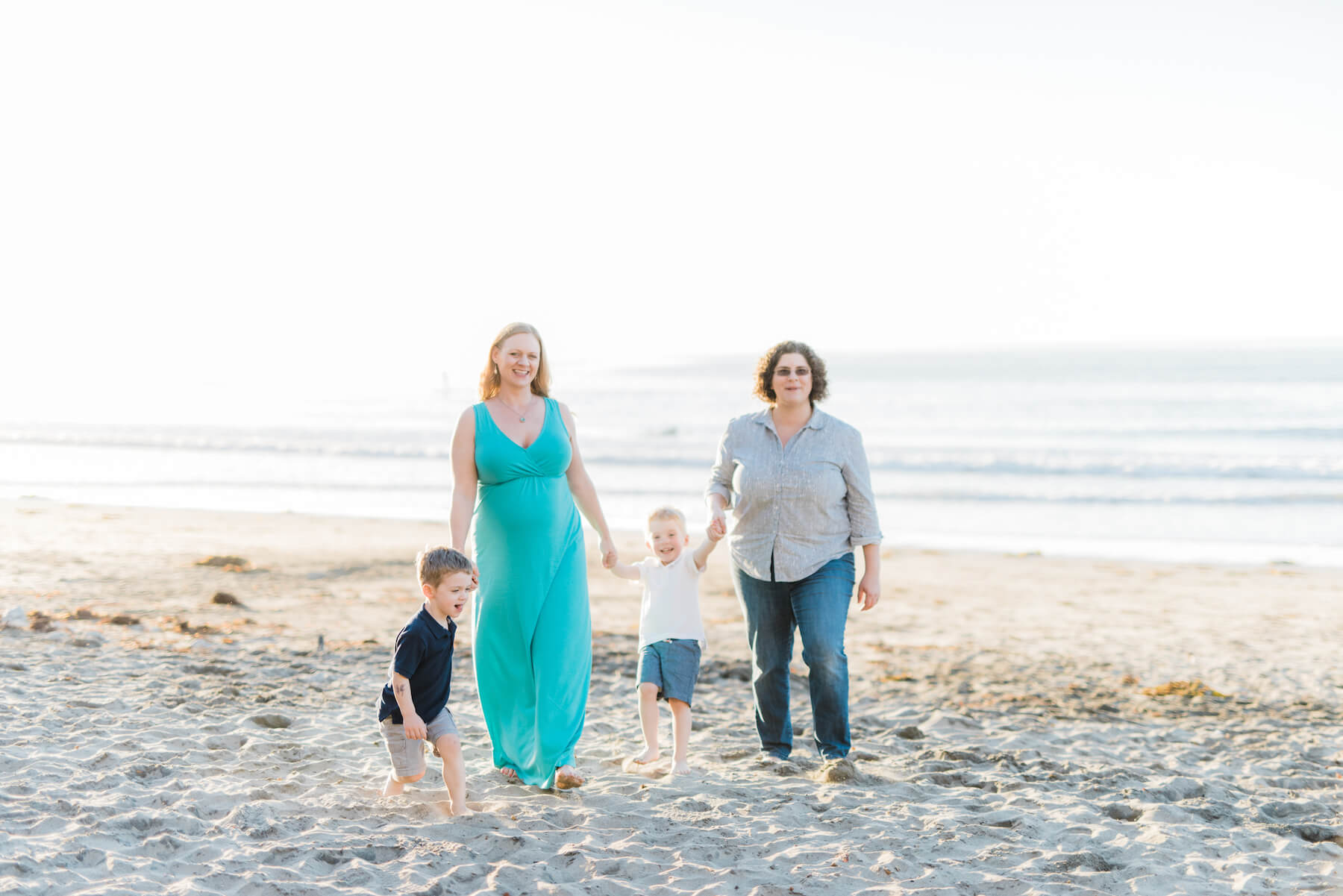 LGBTQ+ family with two young sons on a beach in Los Angeles, California USA