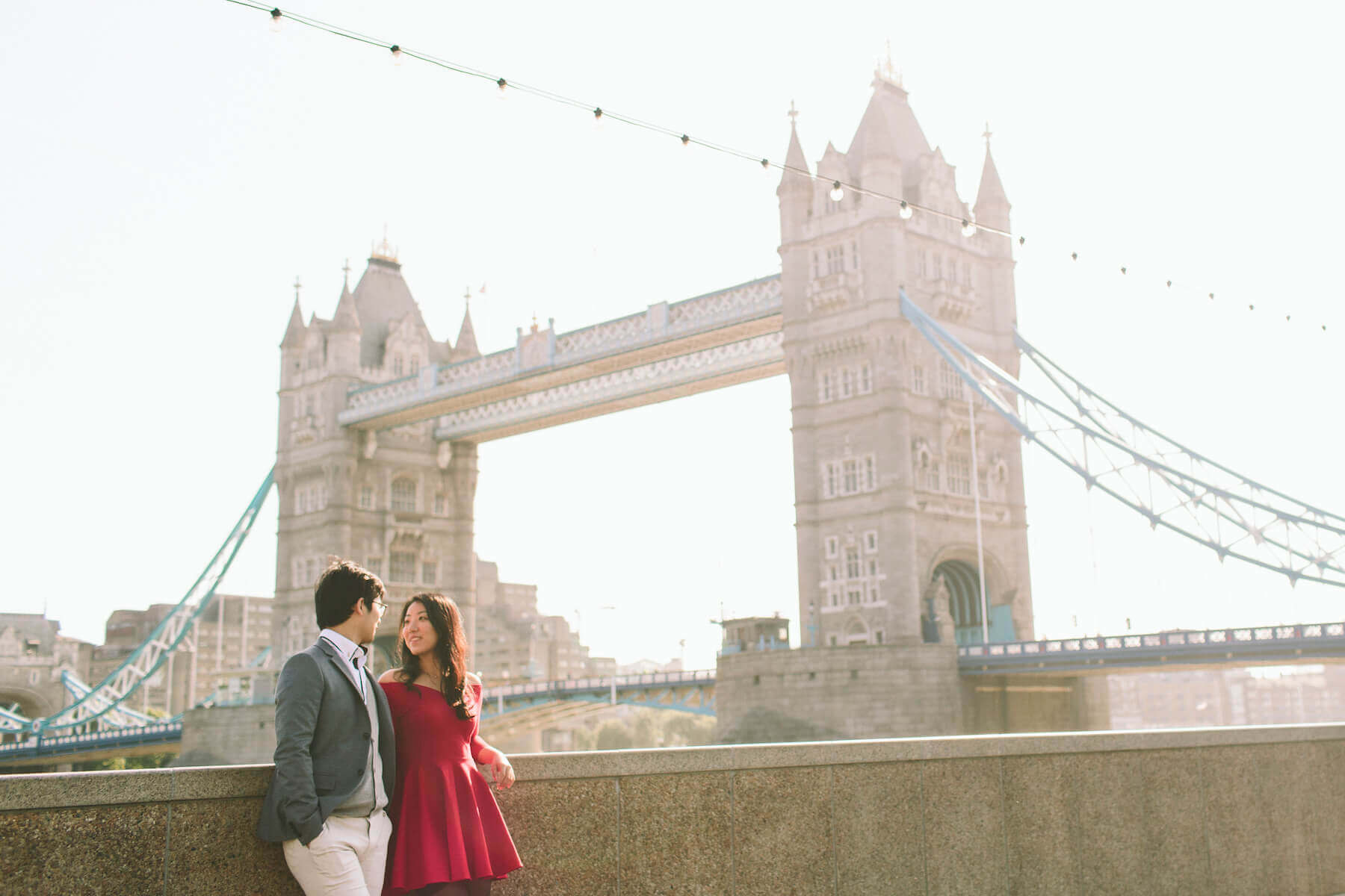 Couple looking lovingly at each other with the Tower Bridge in the background in London, UK