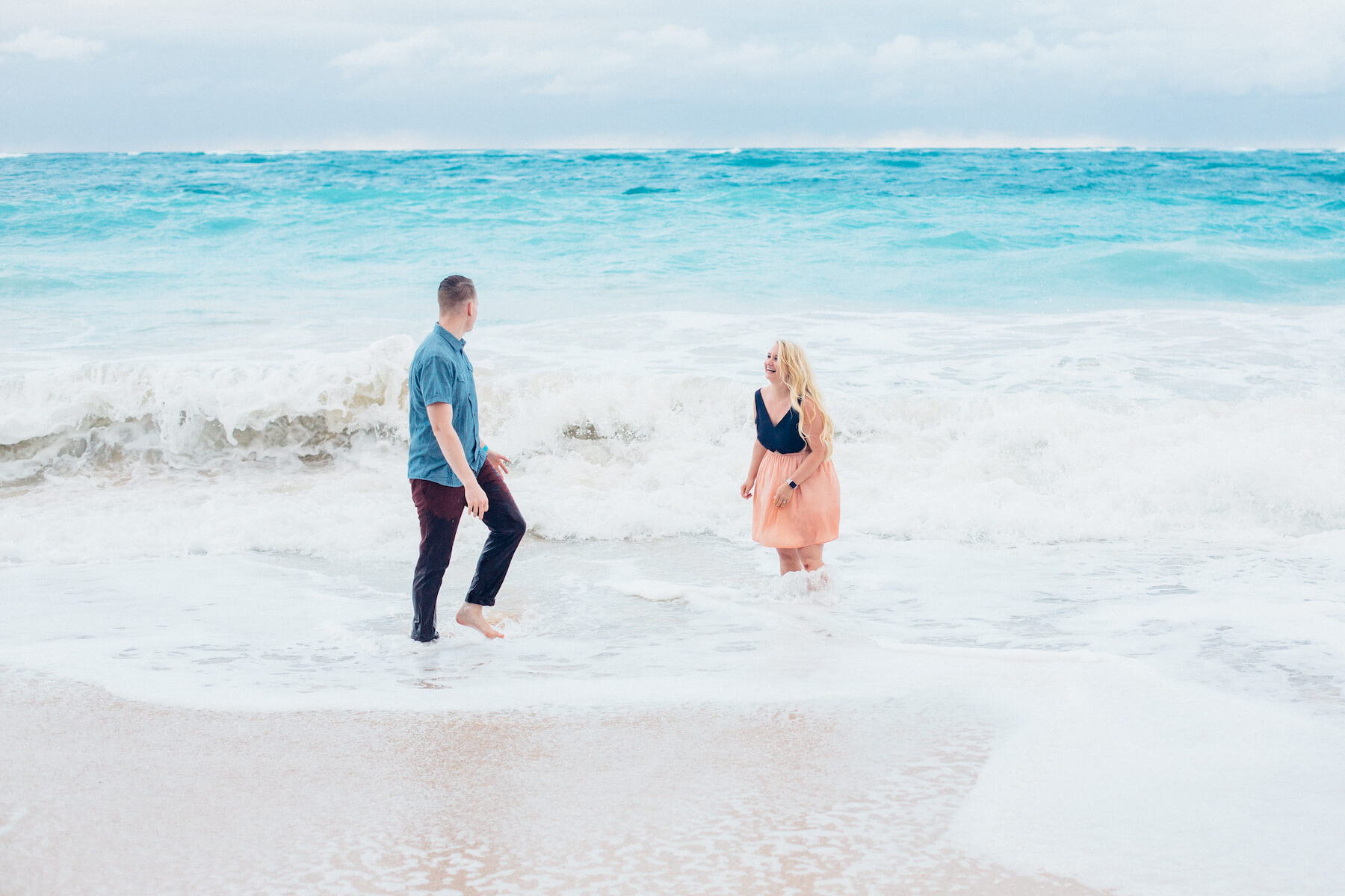 Couple playing in the shallow waves together in Maui, Hawaii USA