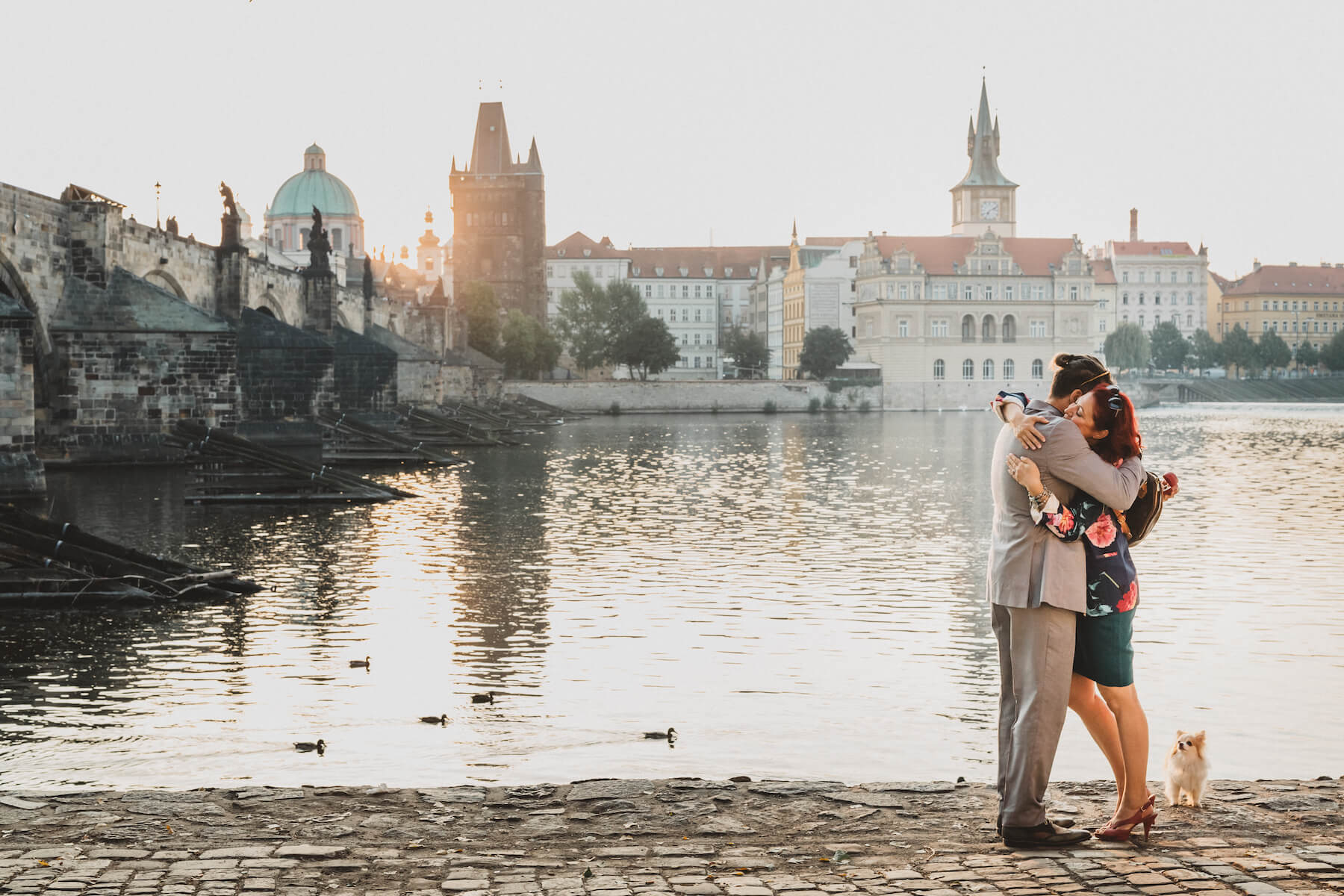 Couple hugging each other after their surprise proposal near a river in Prague, Czech Republic