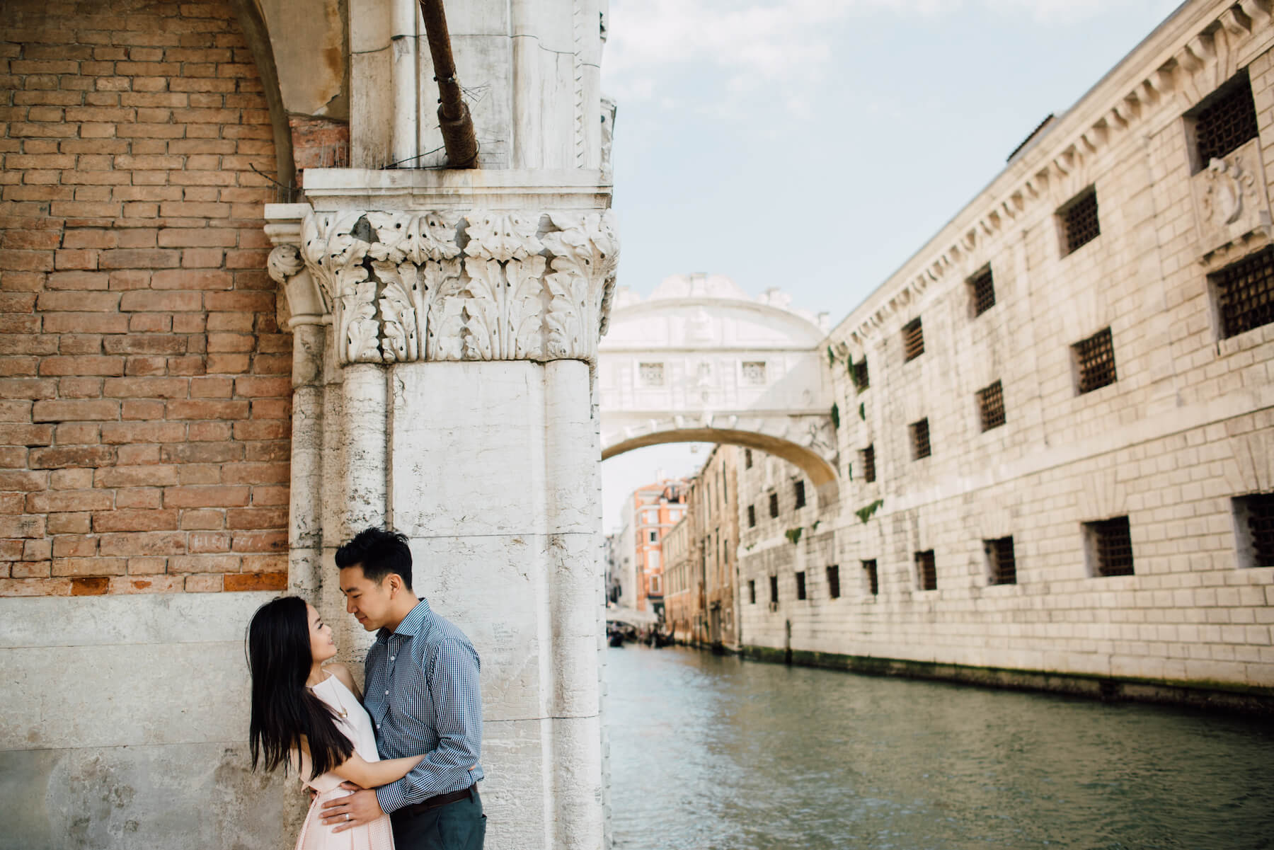 Couple holding each other at the edge of the canal in Venice, Italy