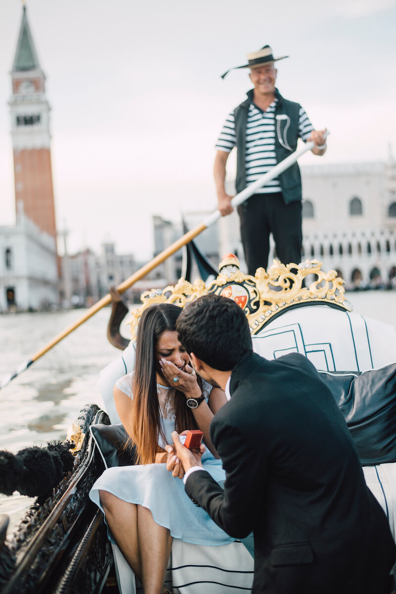 Woman in shock from her partner's surprise proposal on a gondola boat in Venice, Italy