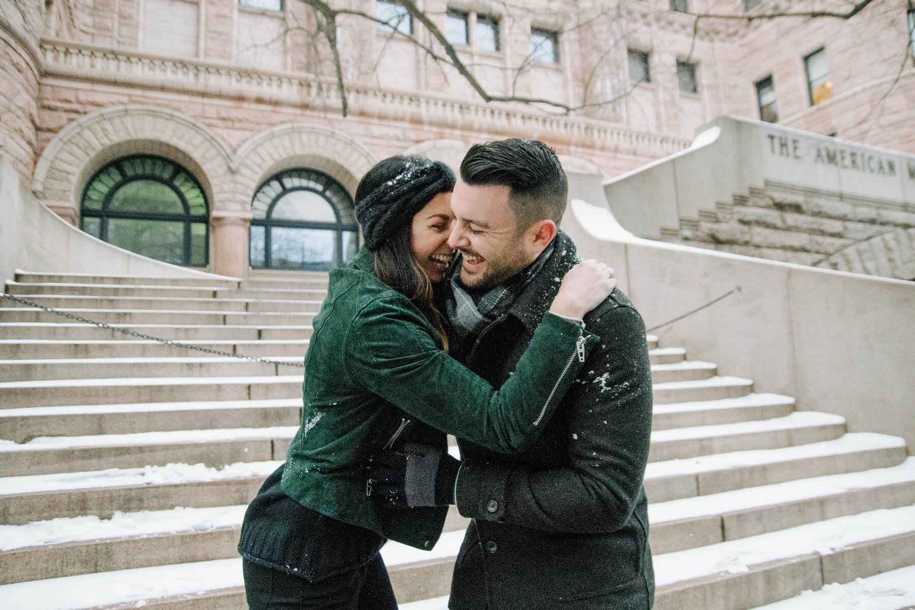 Couple laughing and holding each other in the snow in New York City, USA