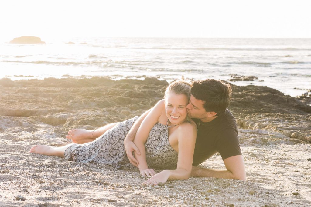 A couple lies on the beach in Tamarindo.