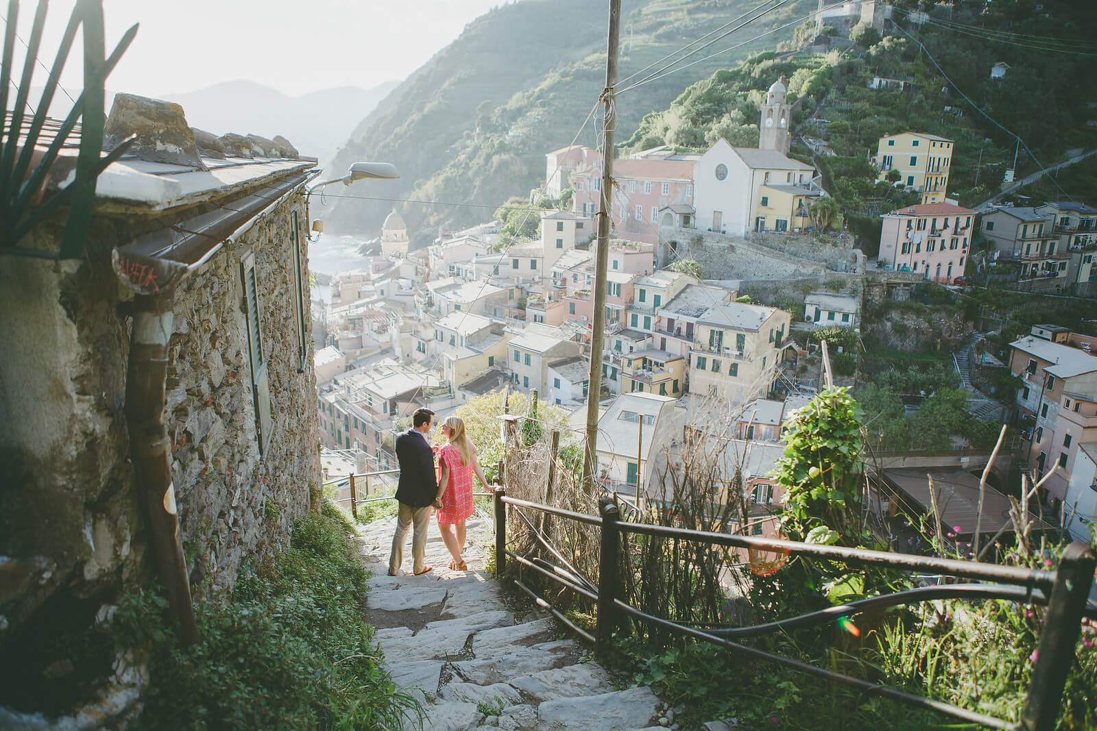 Couple holding hands and walking down stairway in Cinque Terre, Italy