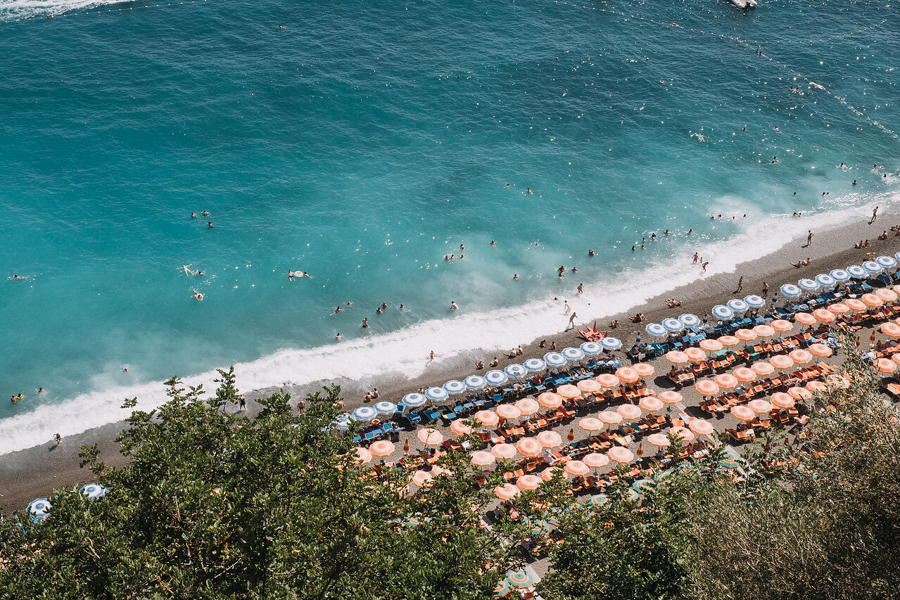 Many people swimming in the water and suntanning at Spiaggia di Laurito beach in Amalfi Coast, Italy