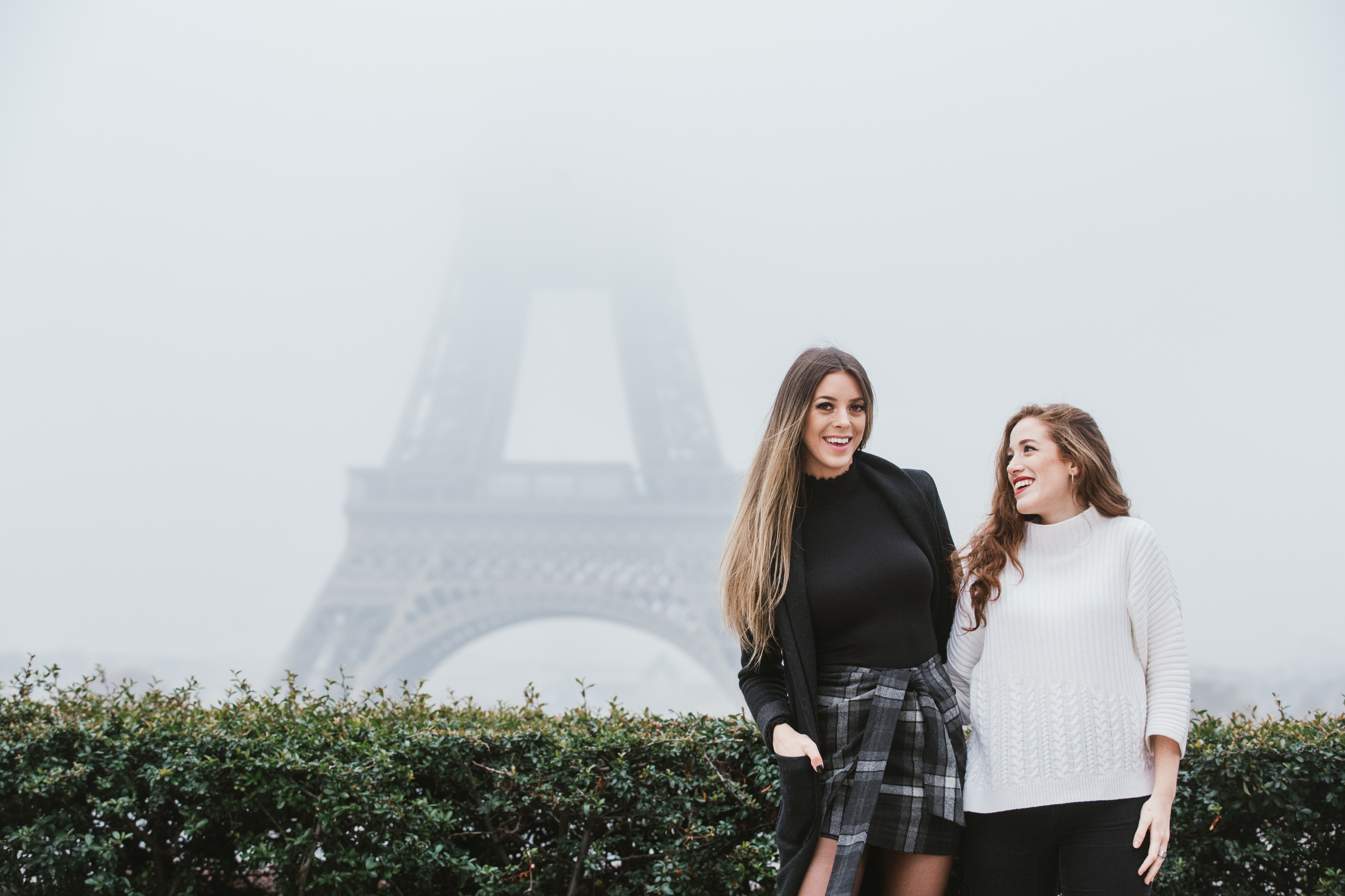 Friends sitting together in front of the Eiffel Tower in Paris, France