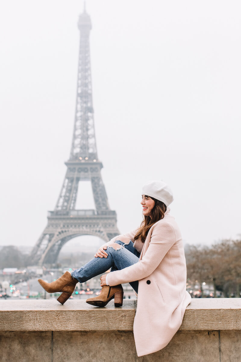 Woman smiling with the Eiffel Tower in the background on a solo photo shoot in Paris, France