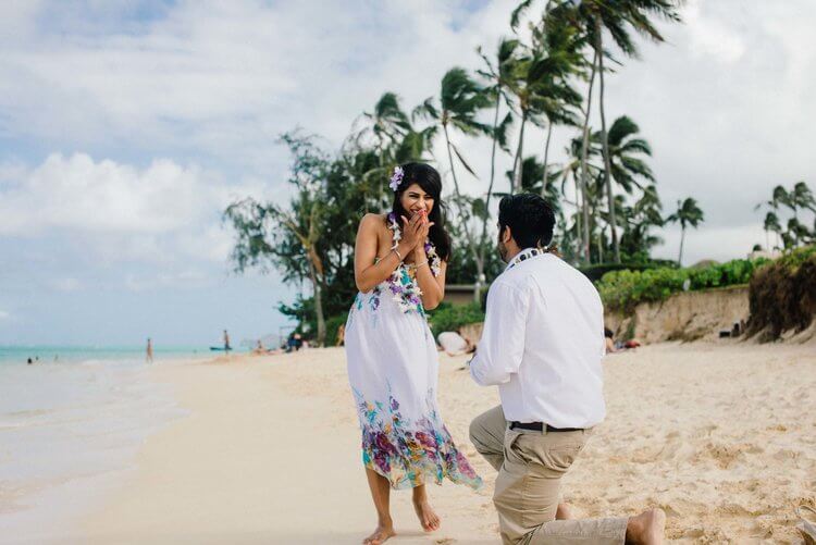 Woman shocked and happy at her partner's surprise proposal on a beach in Honolulu, Hawaii USA