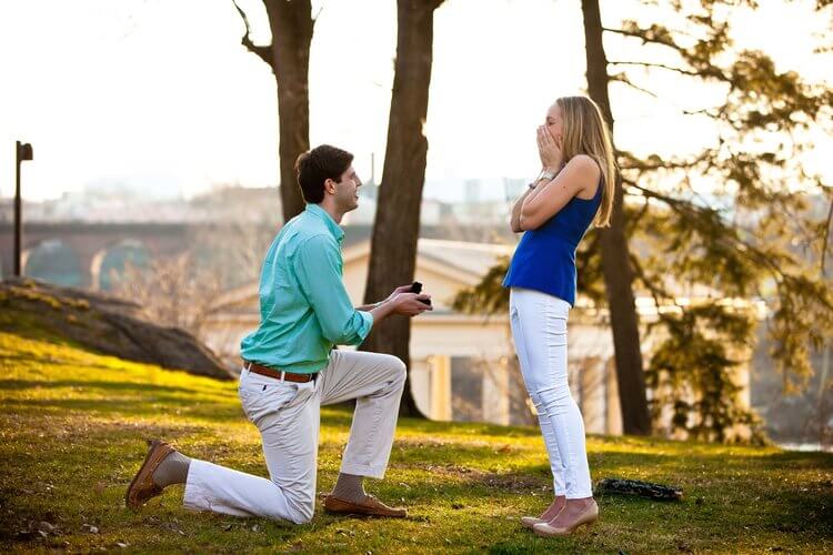 Woman shocked by her partner's surprise proposal in grounds of The Philadelphia Museum of Art in Philadelphia, USA
