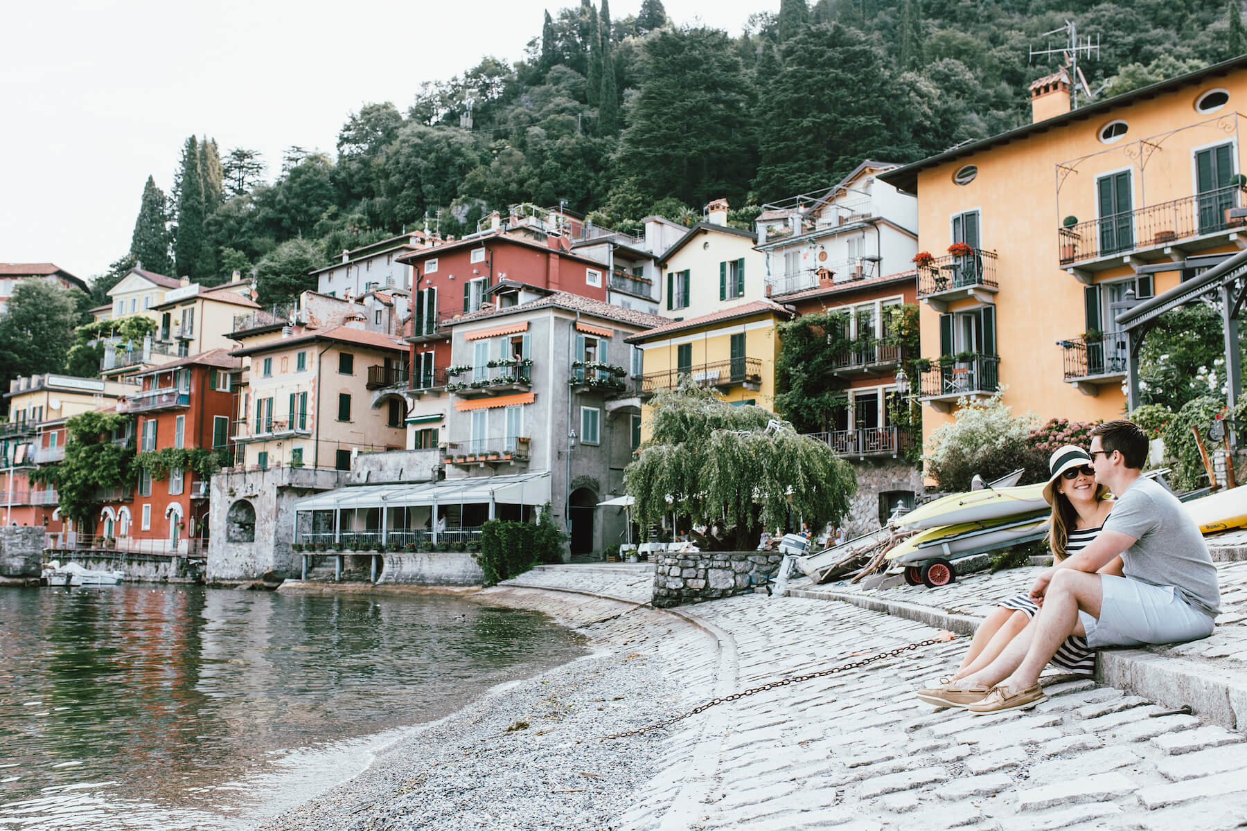 couple sitting down on the beach in lake Como, Italy