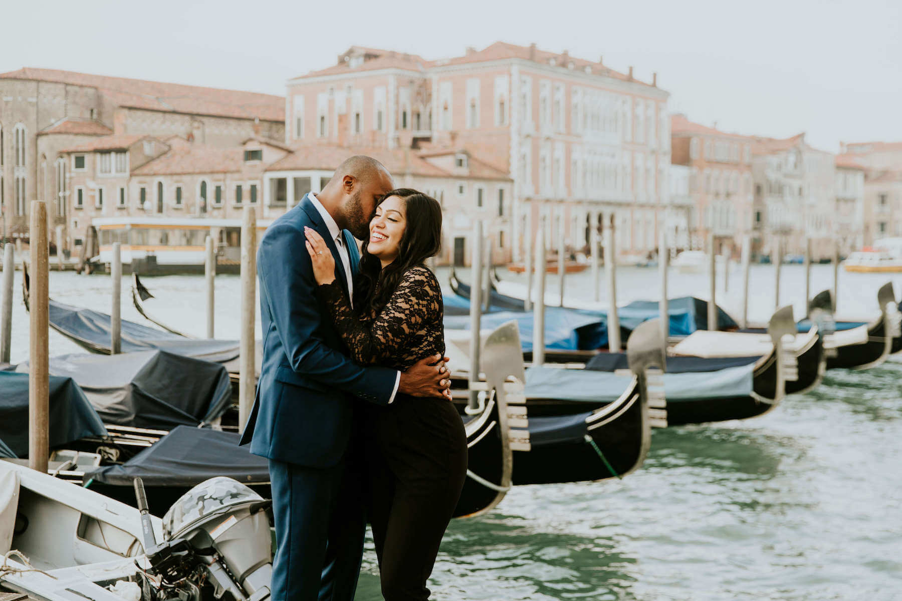 couple holding each other, the man is giving the lady a kiss in Venice, Italy