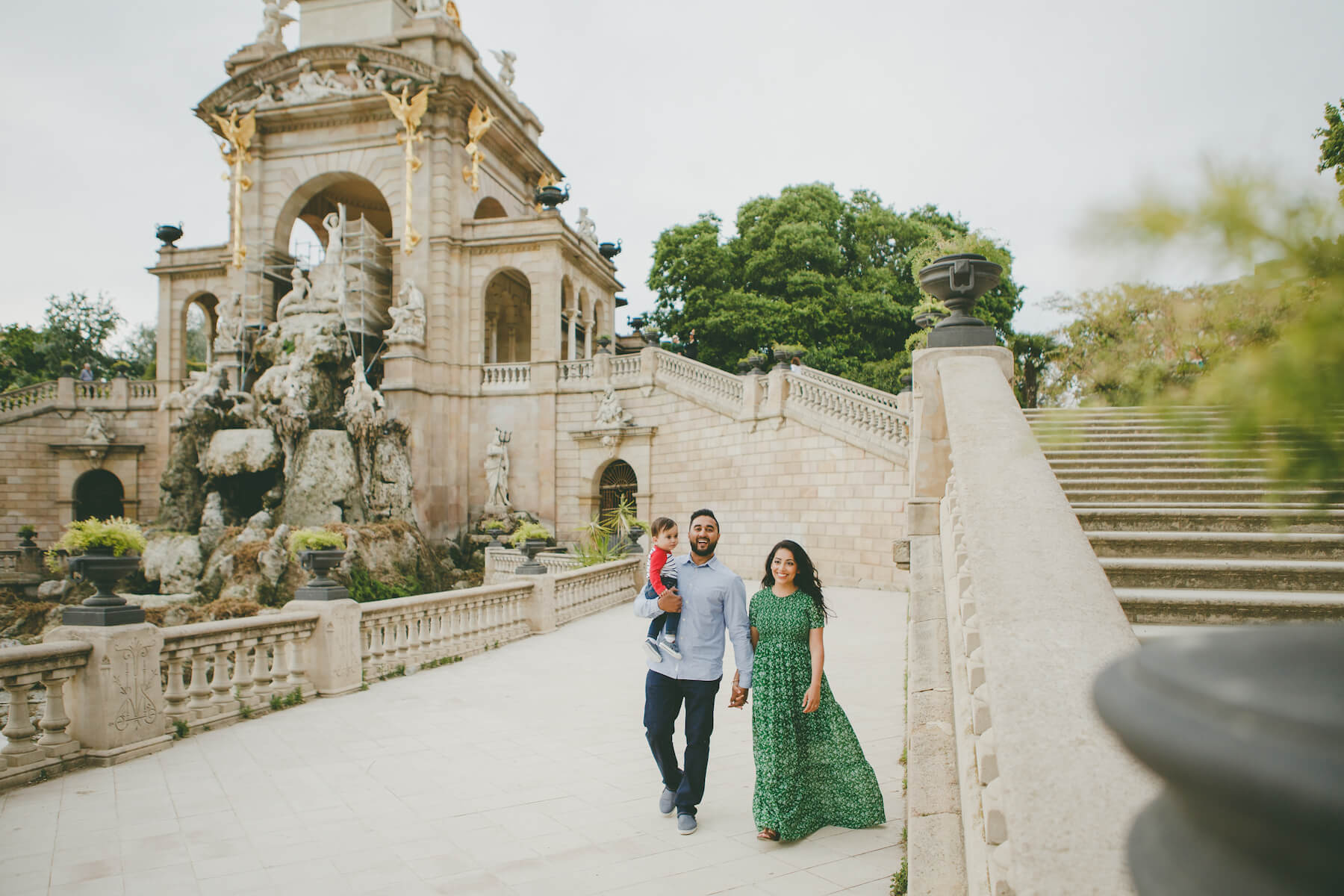 a family with a young child walking in a park in Barcelona, Spain