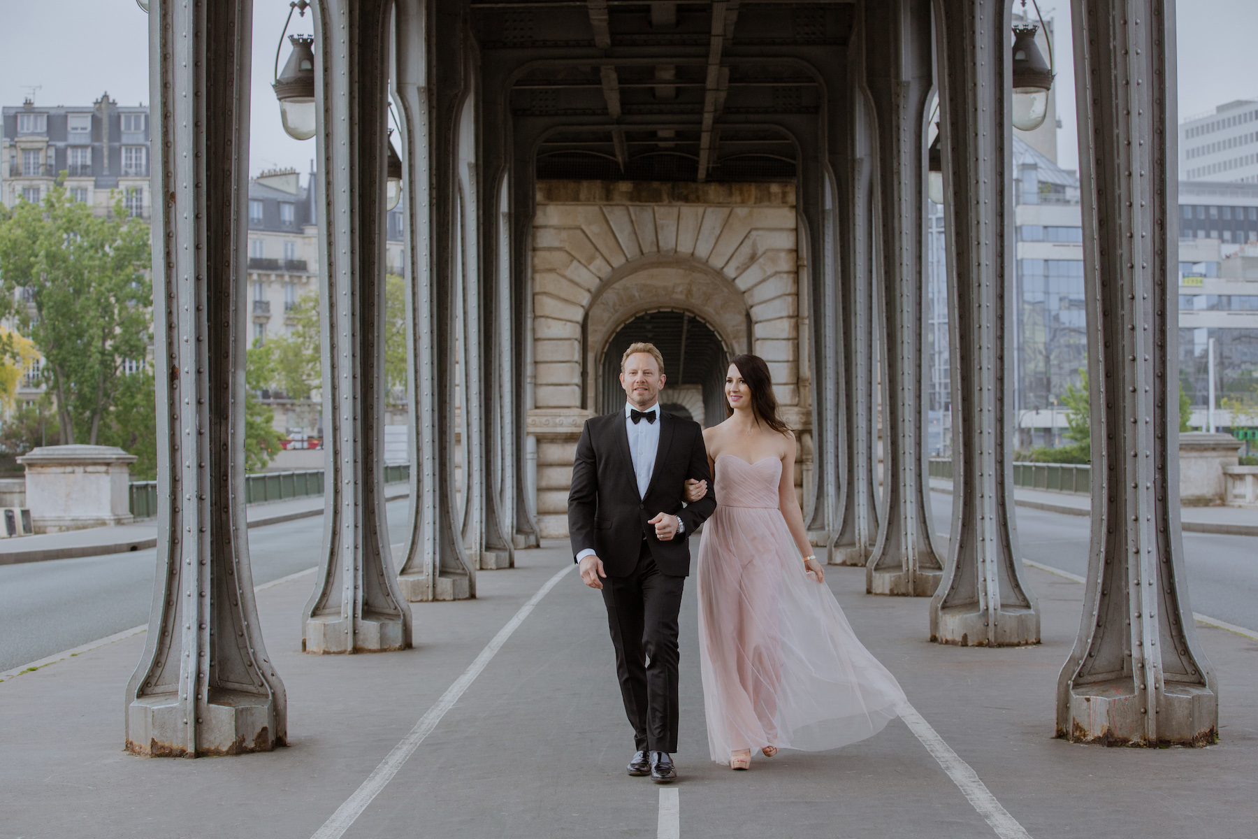 Couple walking dressed up under the bridge in Paris France