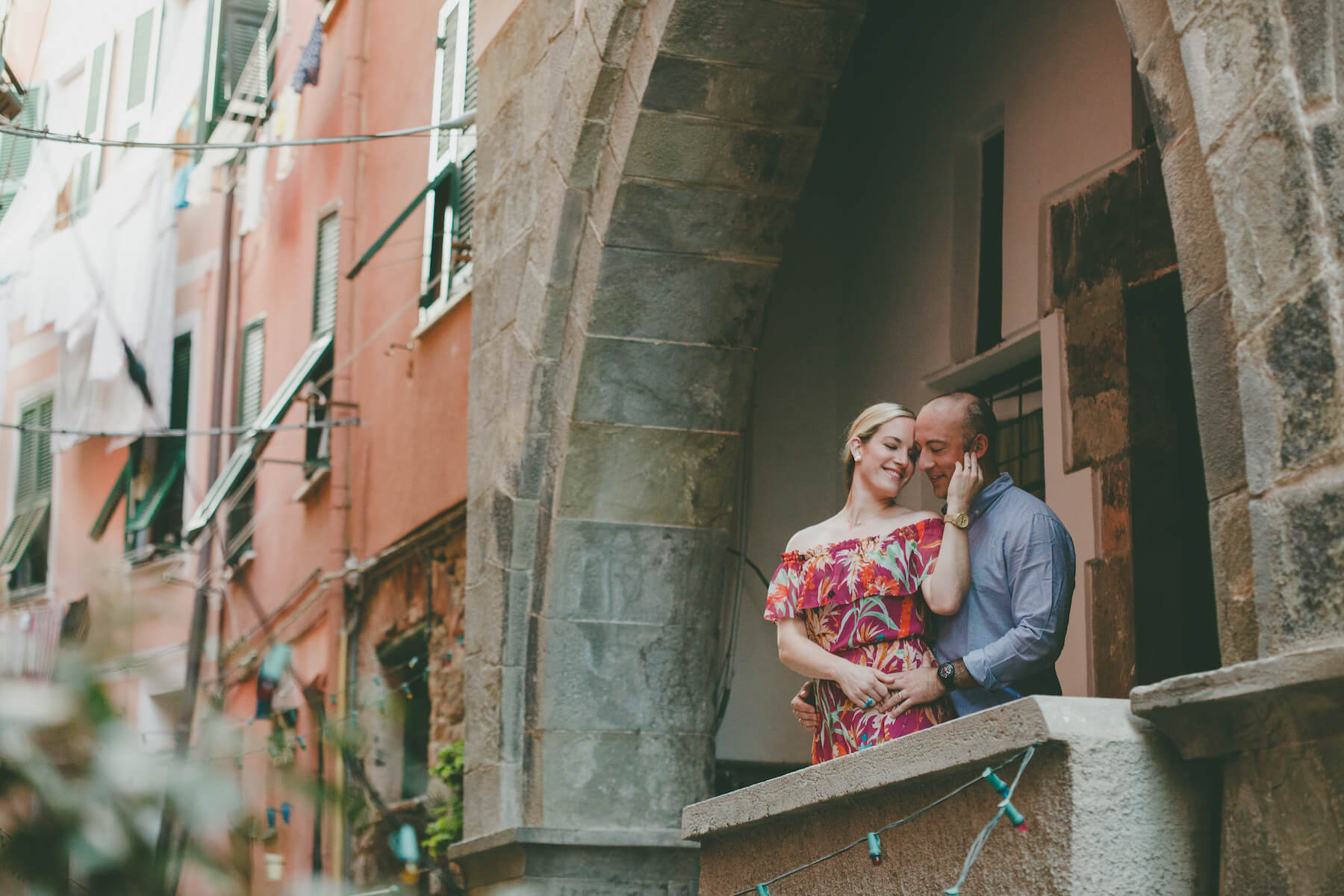 couple holding each other and looking out a window in Cinque Terre, Italy