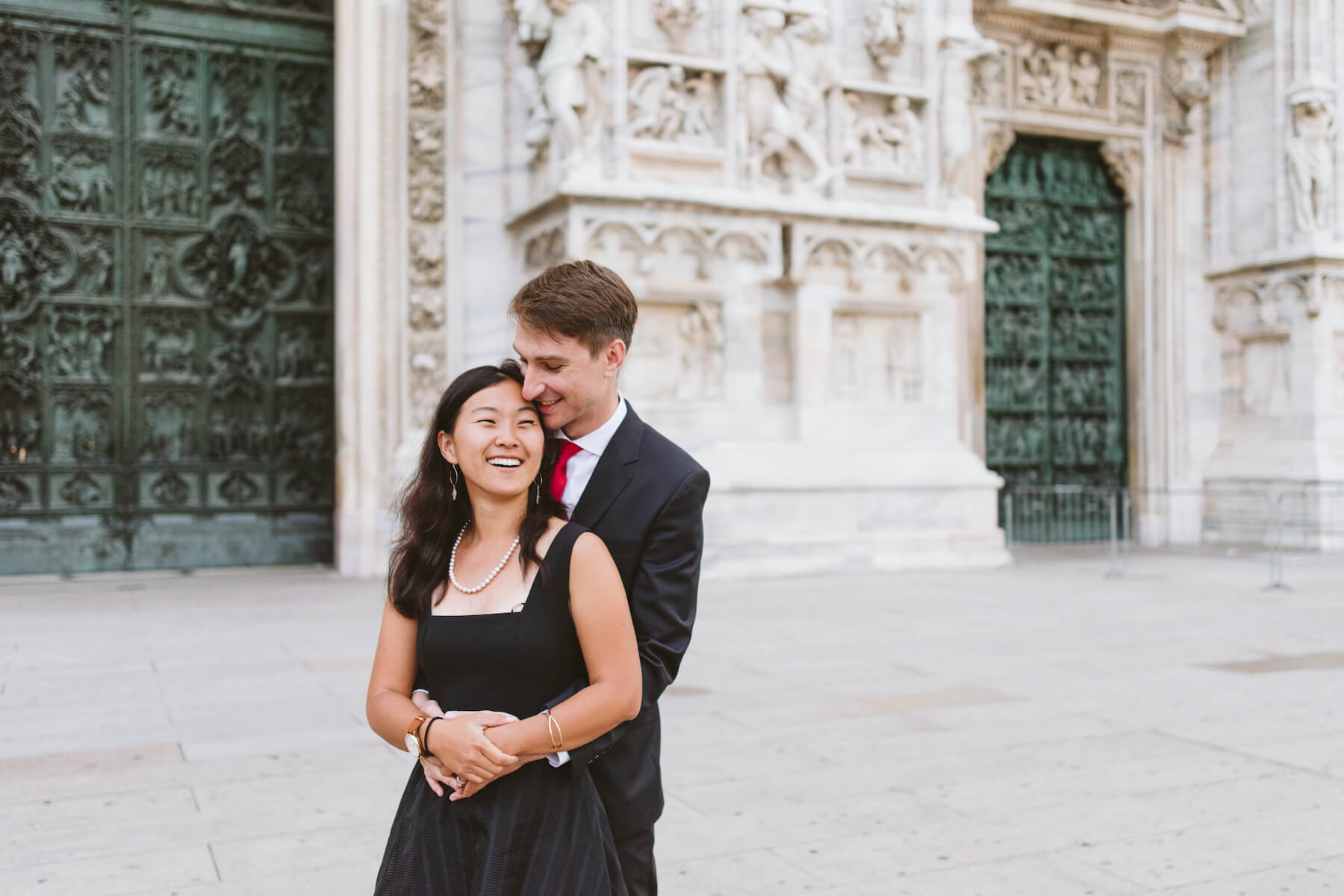 couple holding each other in front of Duomo di Milano, Milan, Italy