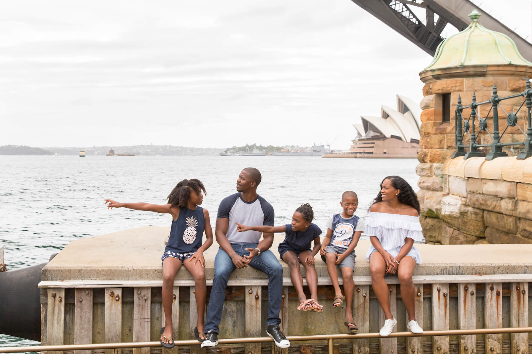 a family of four sitting on the wharf in Sydney, Australia