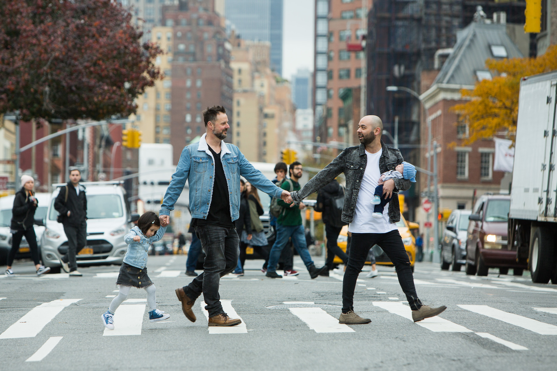 LGBTQ+ family walking across the street holding hands in New York City, New York
