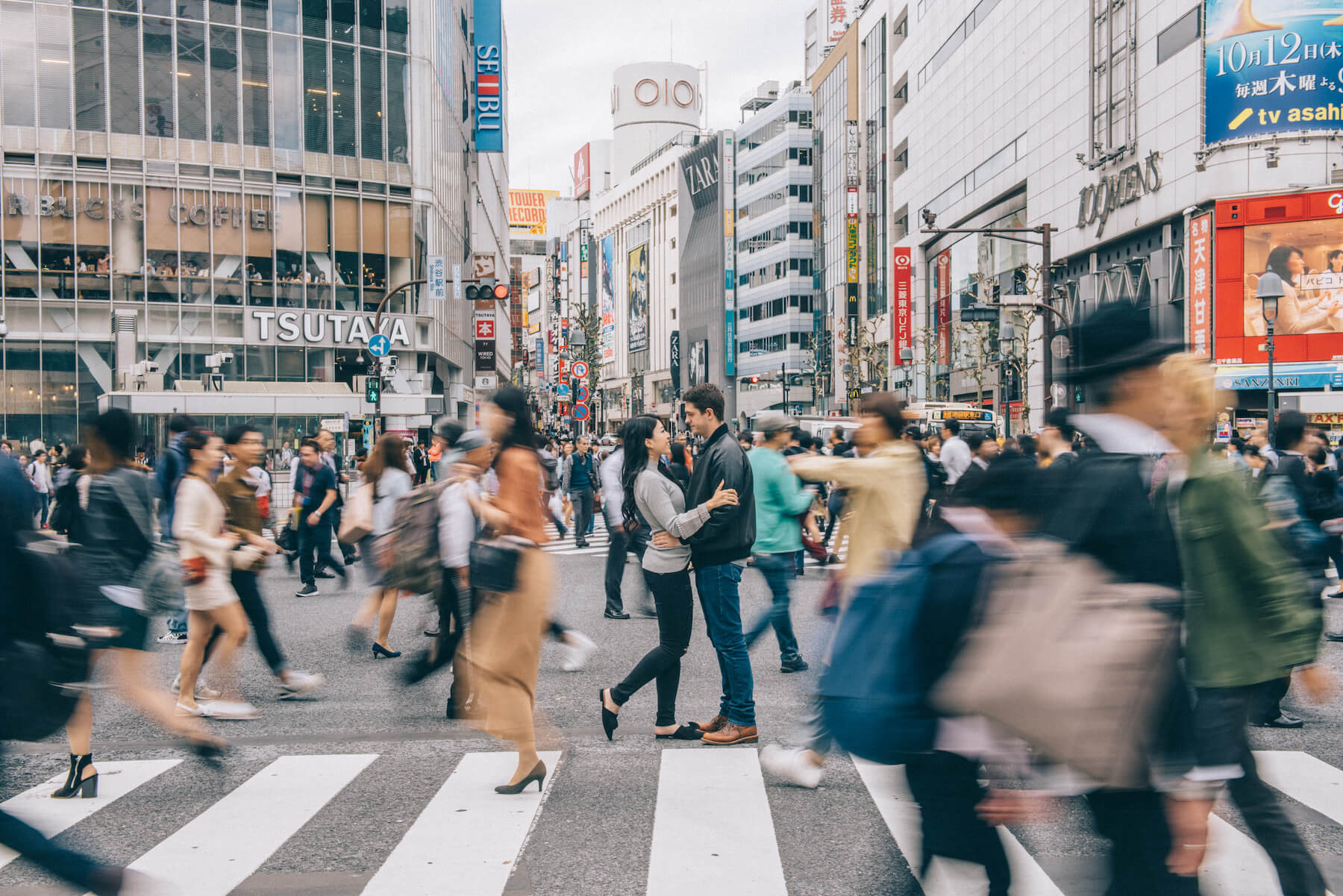 Couple hugging each other in the middle of Shibuya crossing, Tokyo, Japan