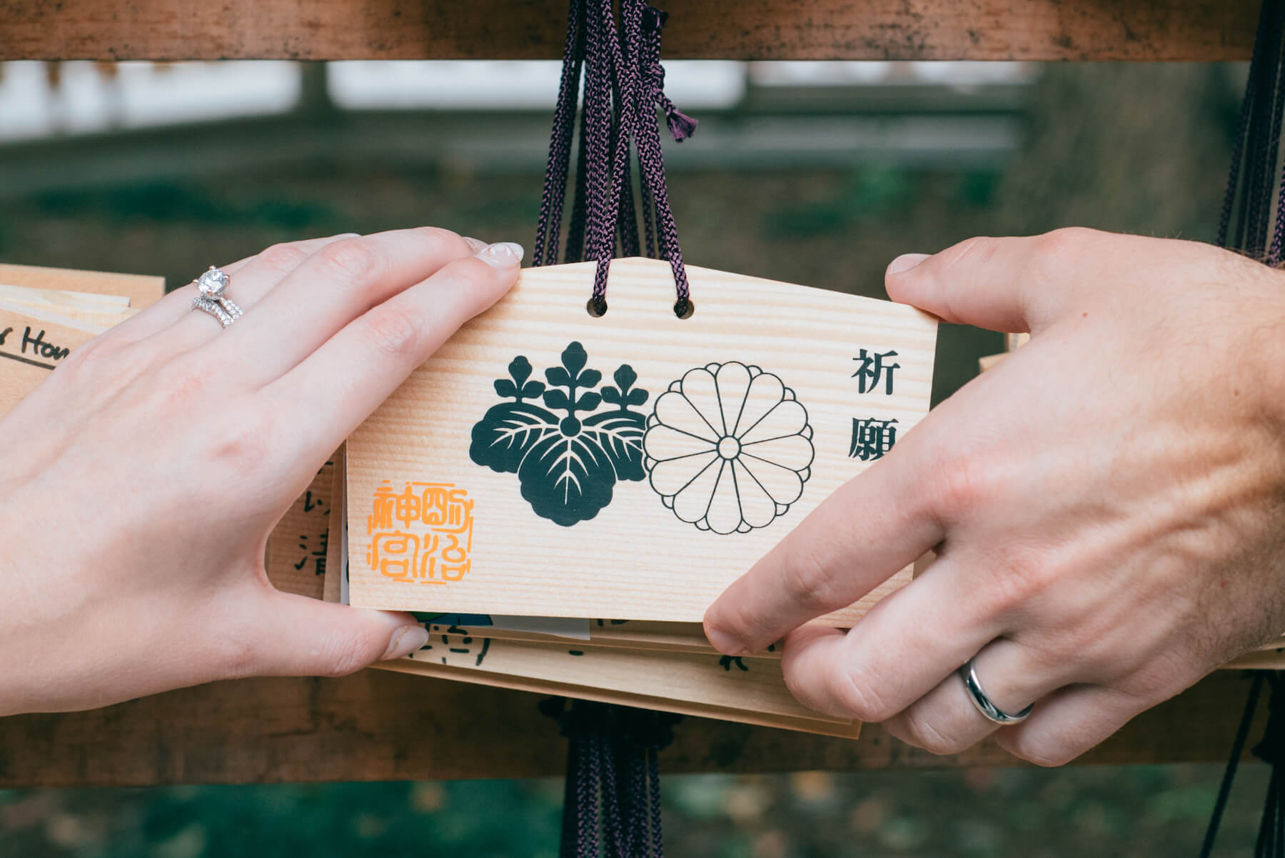 couple holding a sign at Meiji Shrine, Tokyo Japan
