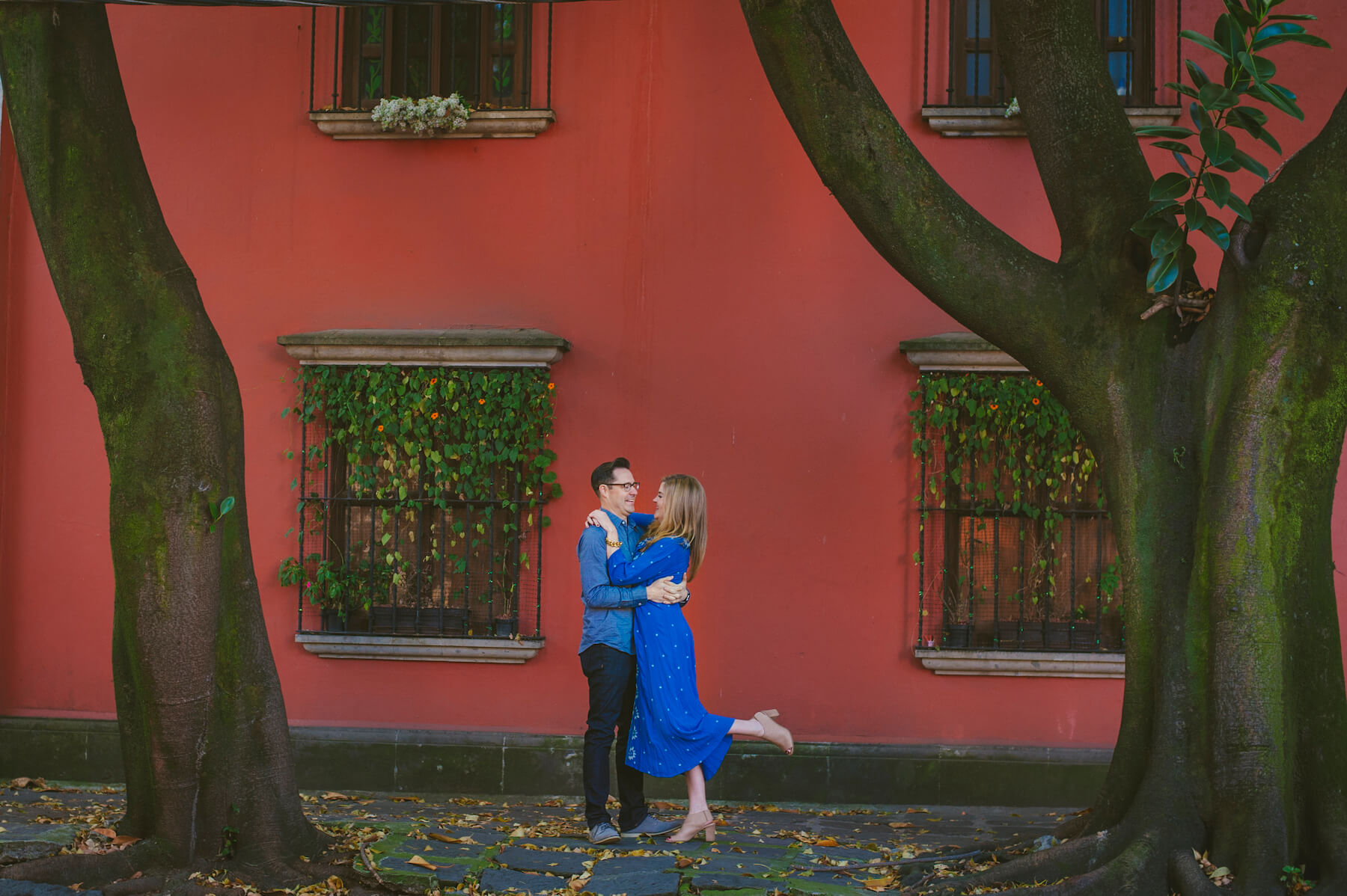 couple hugging each other in front of a colorful building in Mexico City, Mexico
