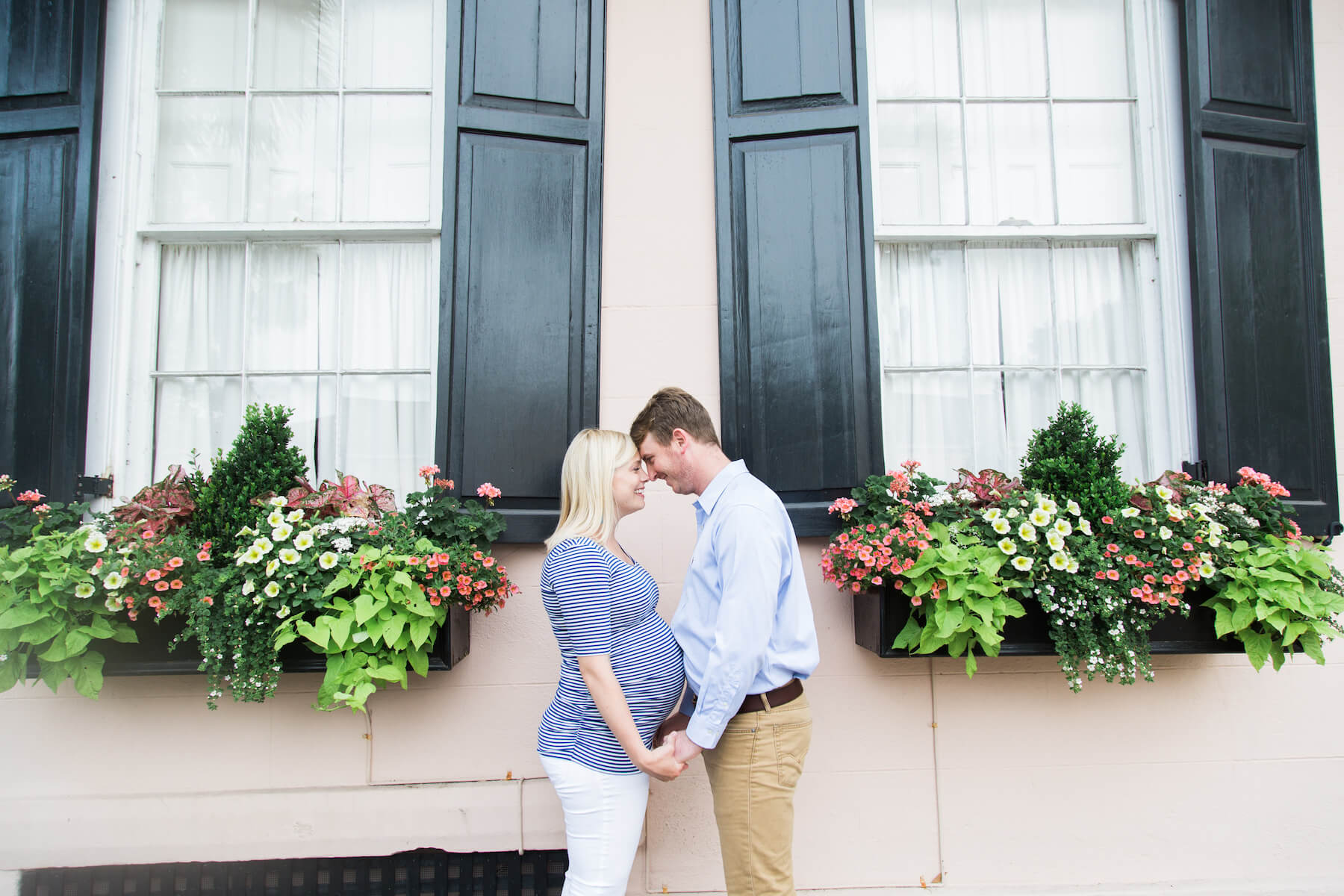 Couple looking at each other and holding hands in front of pretty flower boxes in Charleston, South Carolina