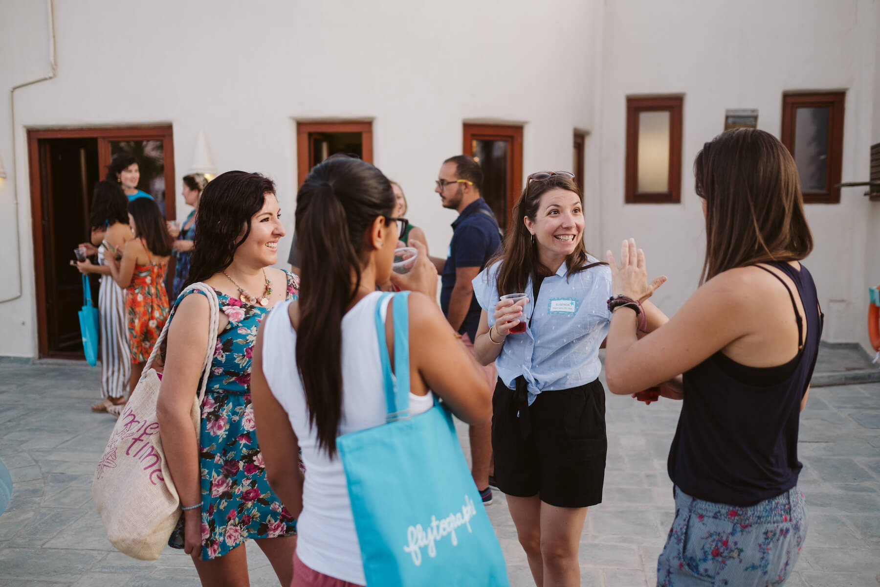 A group of women laughing around the pool in Santorini, Greece