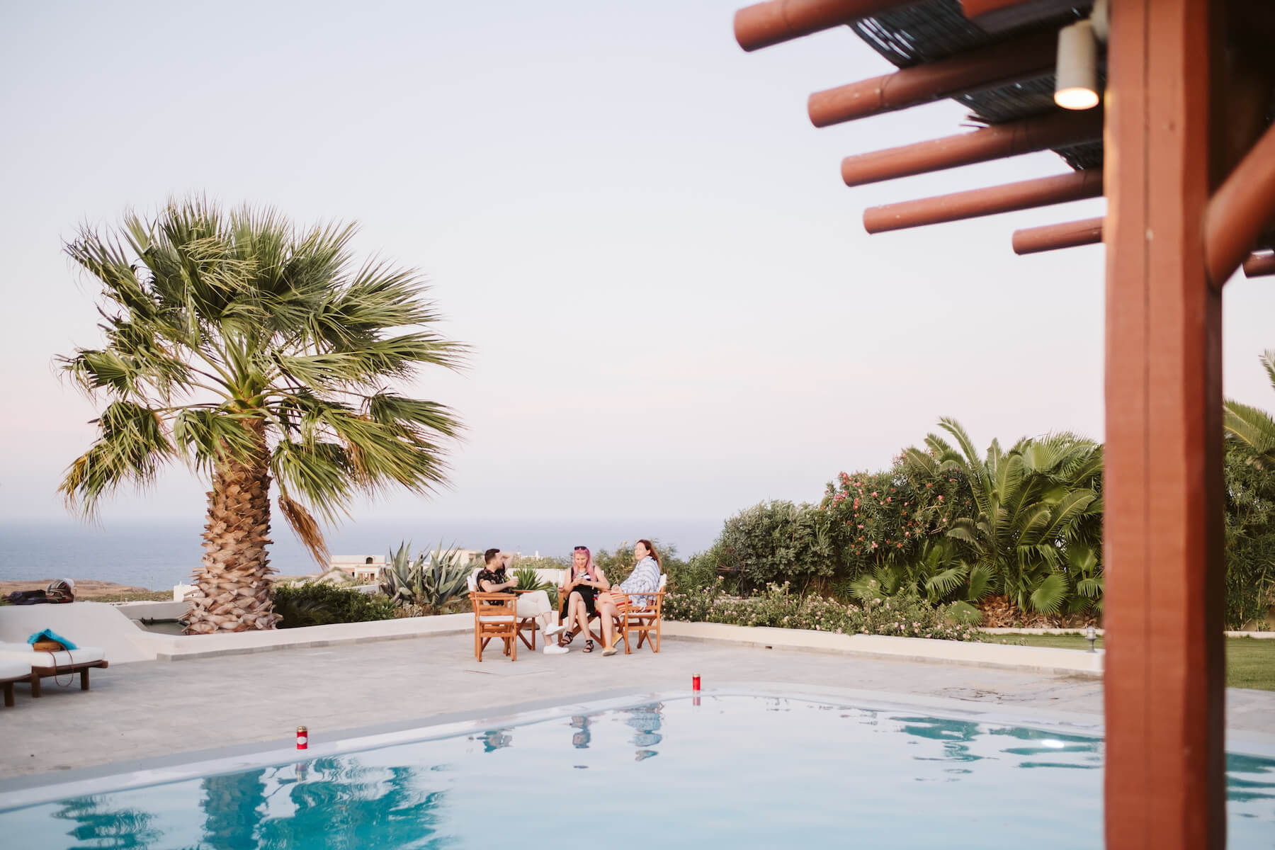 People sitting around a pool talking in Santorini, Greece