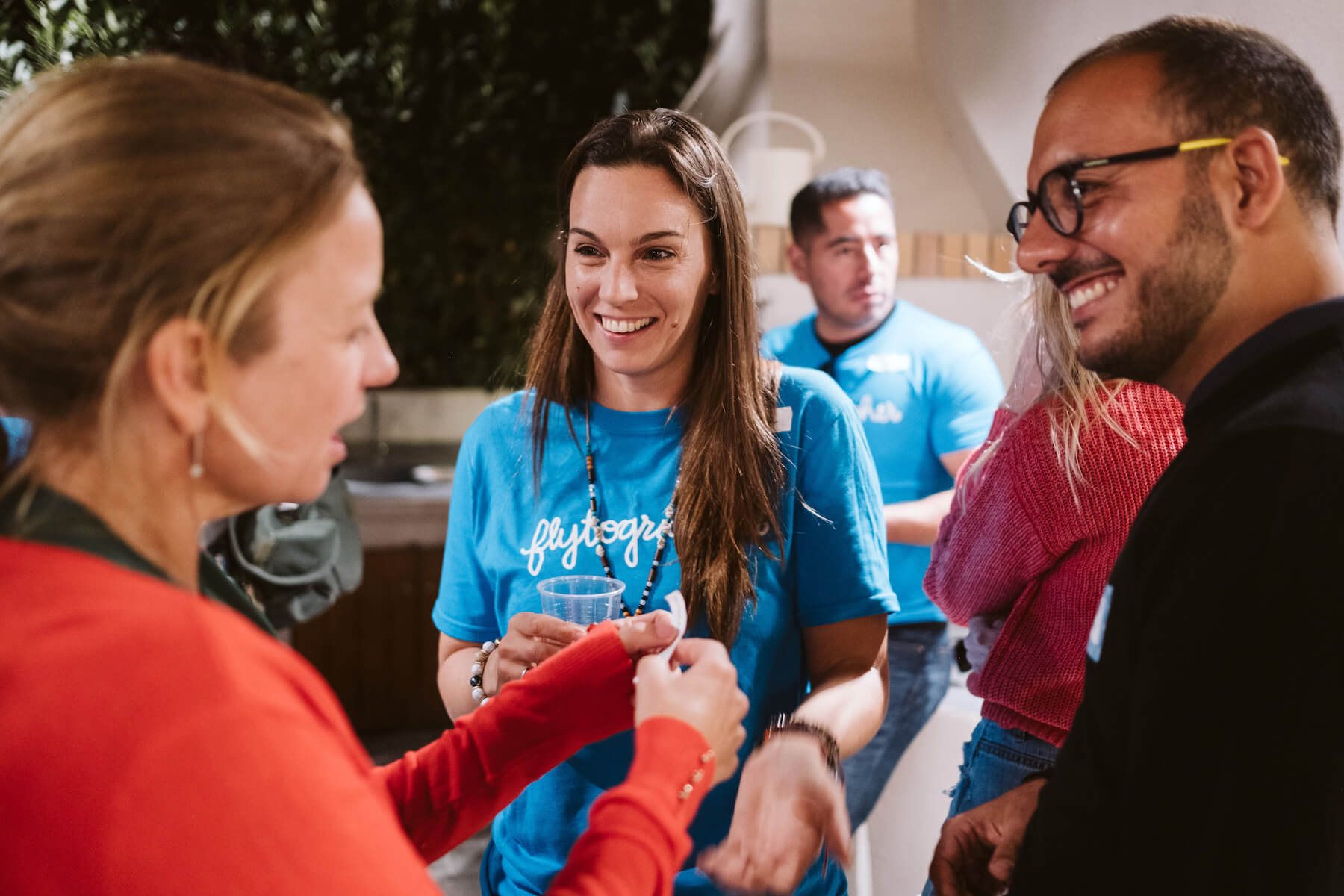 Three people smiling and talking at a house in Santorini, Greece