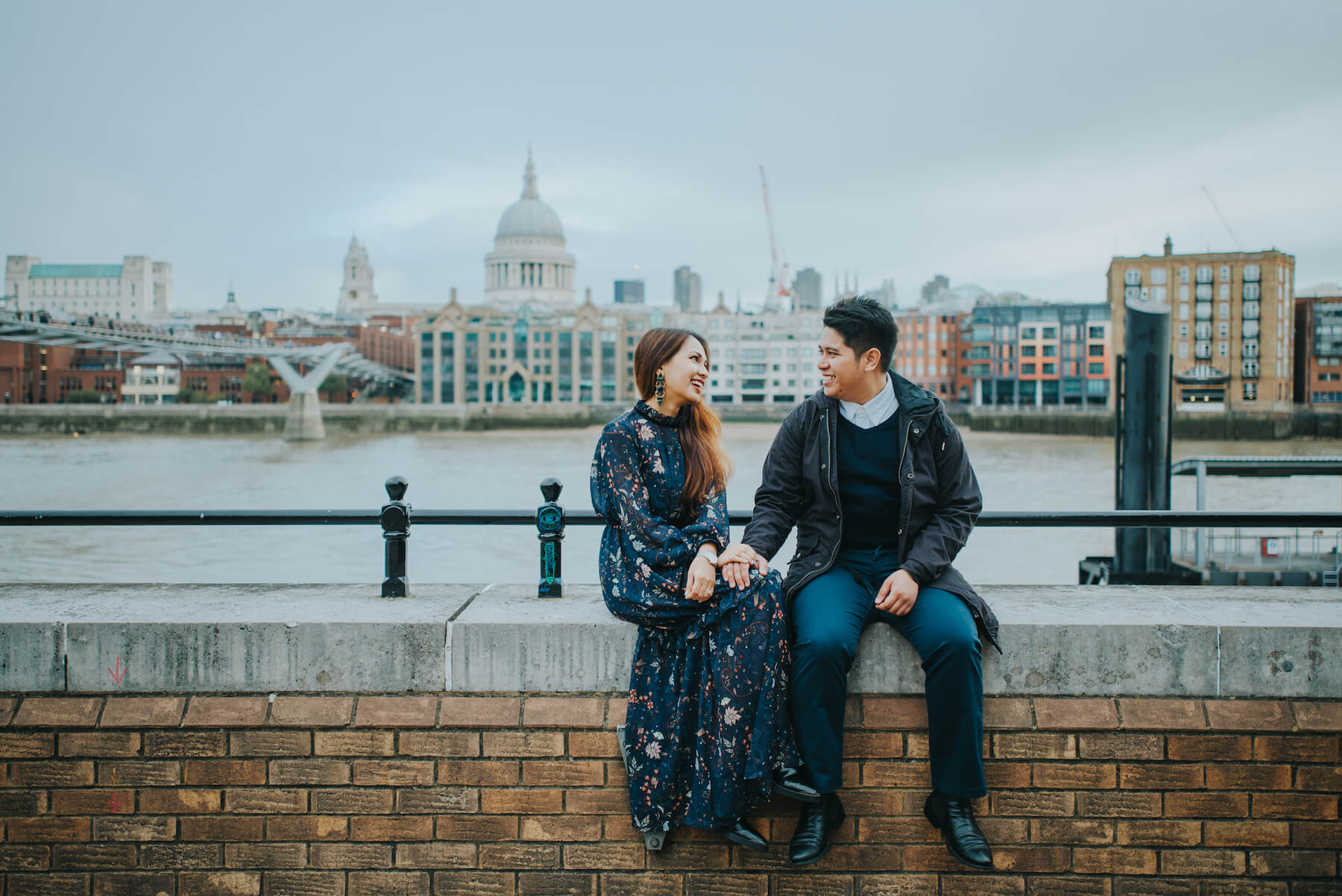 couple sitting on a bridge in London, England