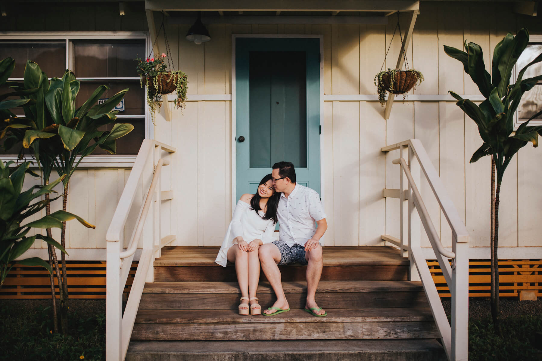 A couple sitting on a porch of a surf shack in Honolulu, Hawaii