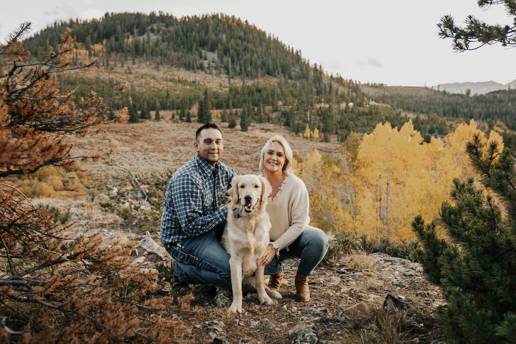 a couple with their dog sitting down in a field in Breckenridge, United States