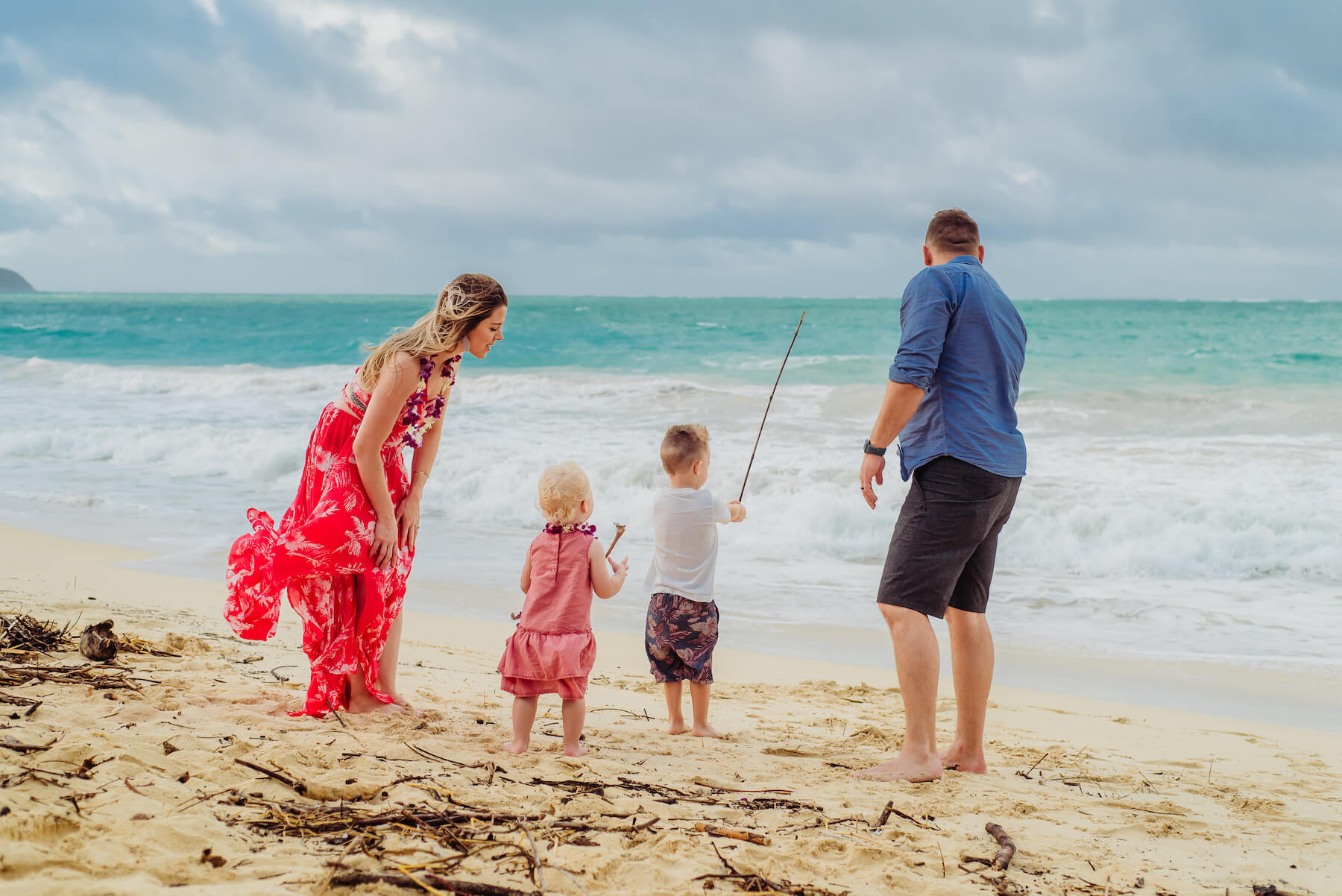 A family fishing in the water and playing on the beach in Honolulu, Hawaii