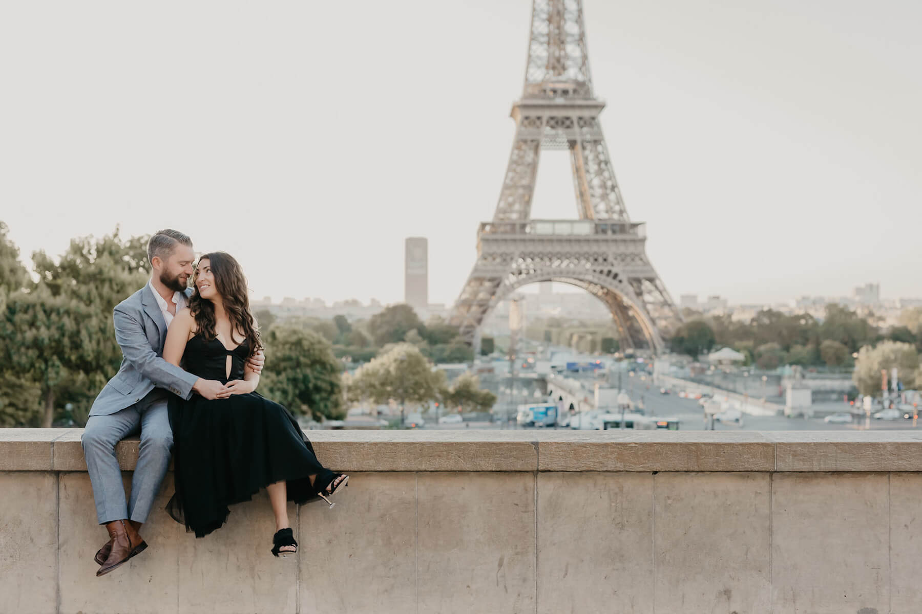 couple sitting in front of the Eiffel Tower in Paris, France