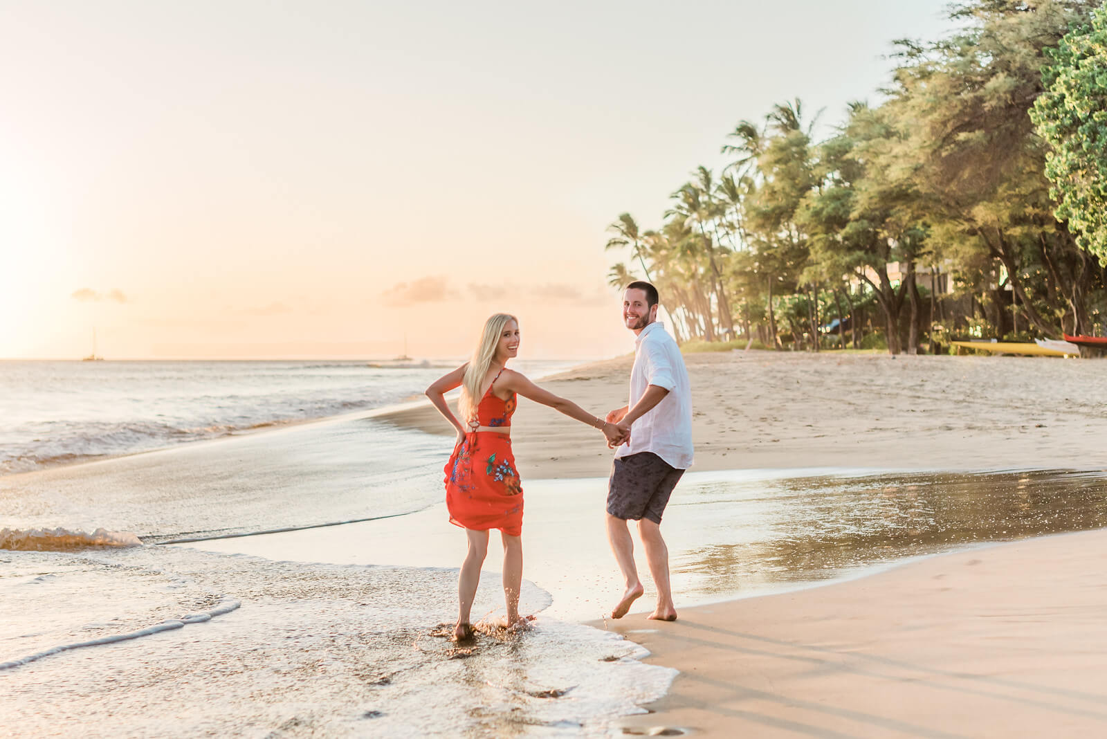 Couple holding hands walking on the beach in Maui, Hawaii