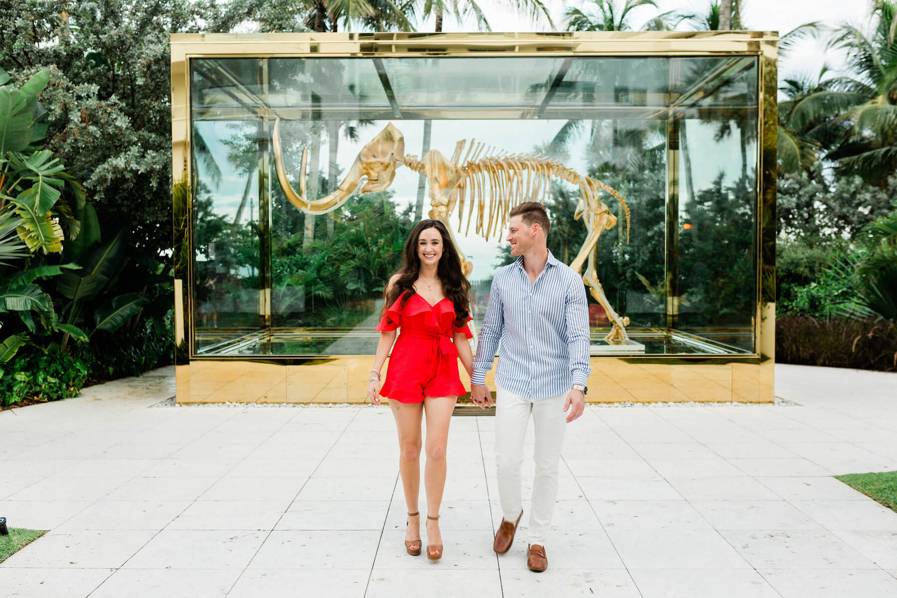 Couple walking in front of a Dinosaur exhibit in Miami, Florida