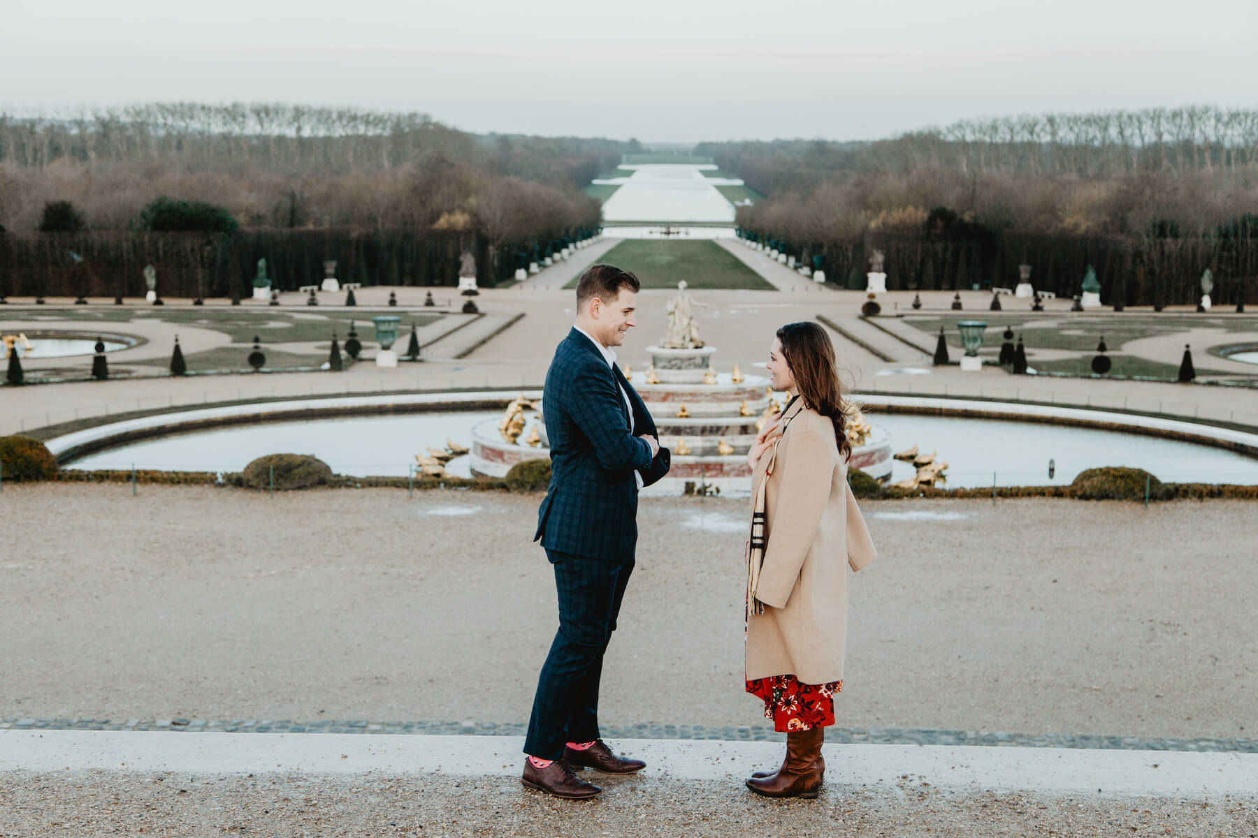 A man proposing to a woman on Versailles palace grounds in Paris, France