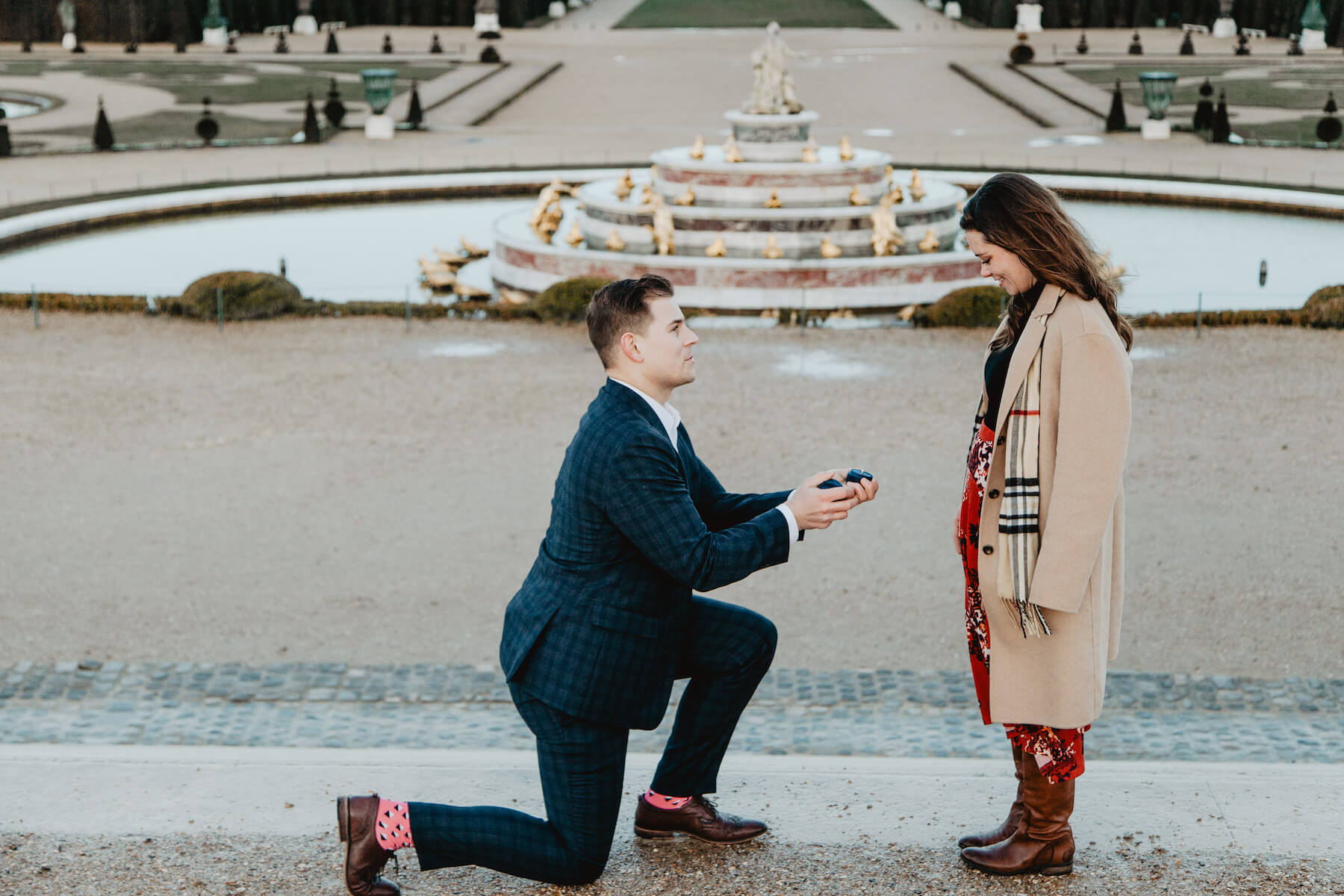 A man proposing to a woman on Versailles palace grounds in Paris, France