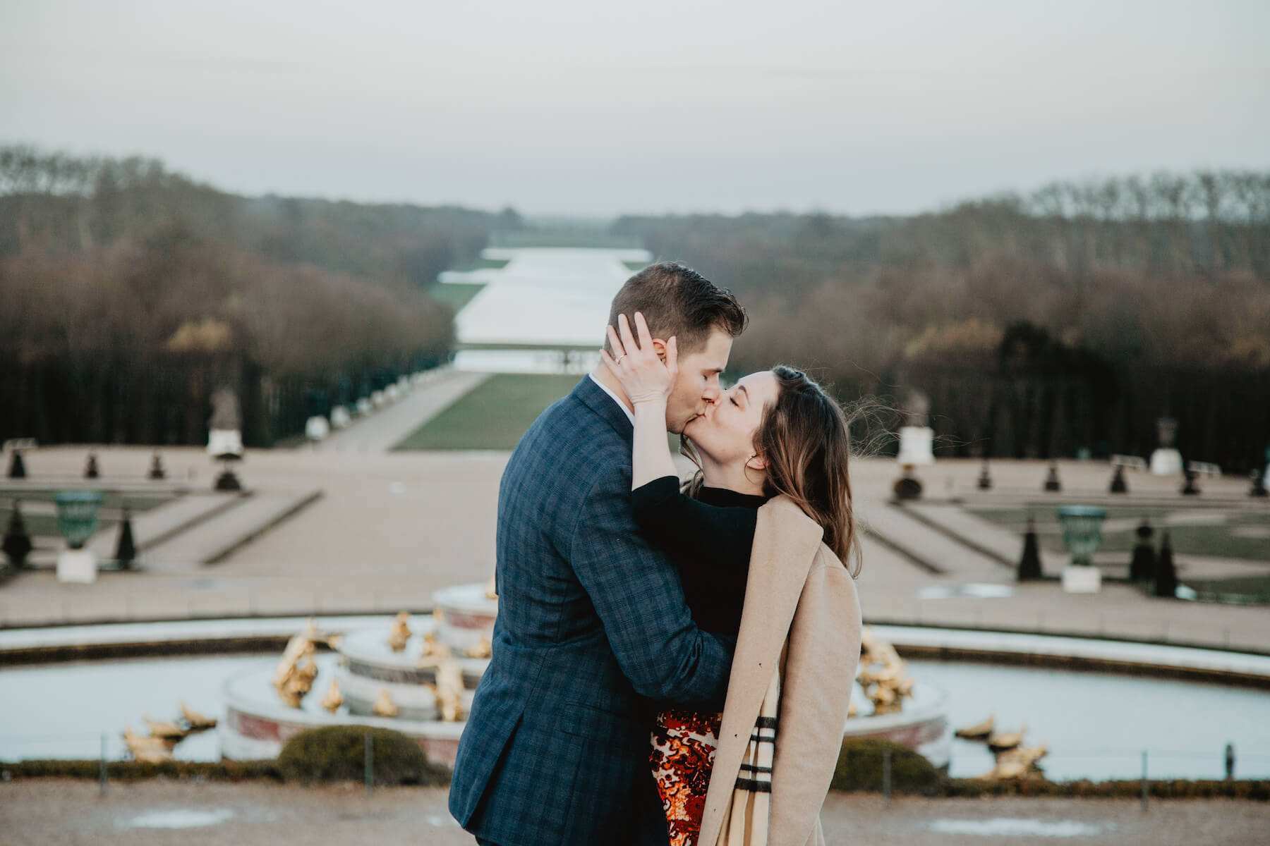 A couple kissing on Versailles palace grounds in Paris, France